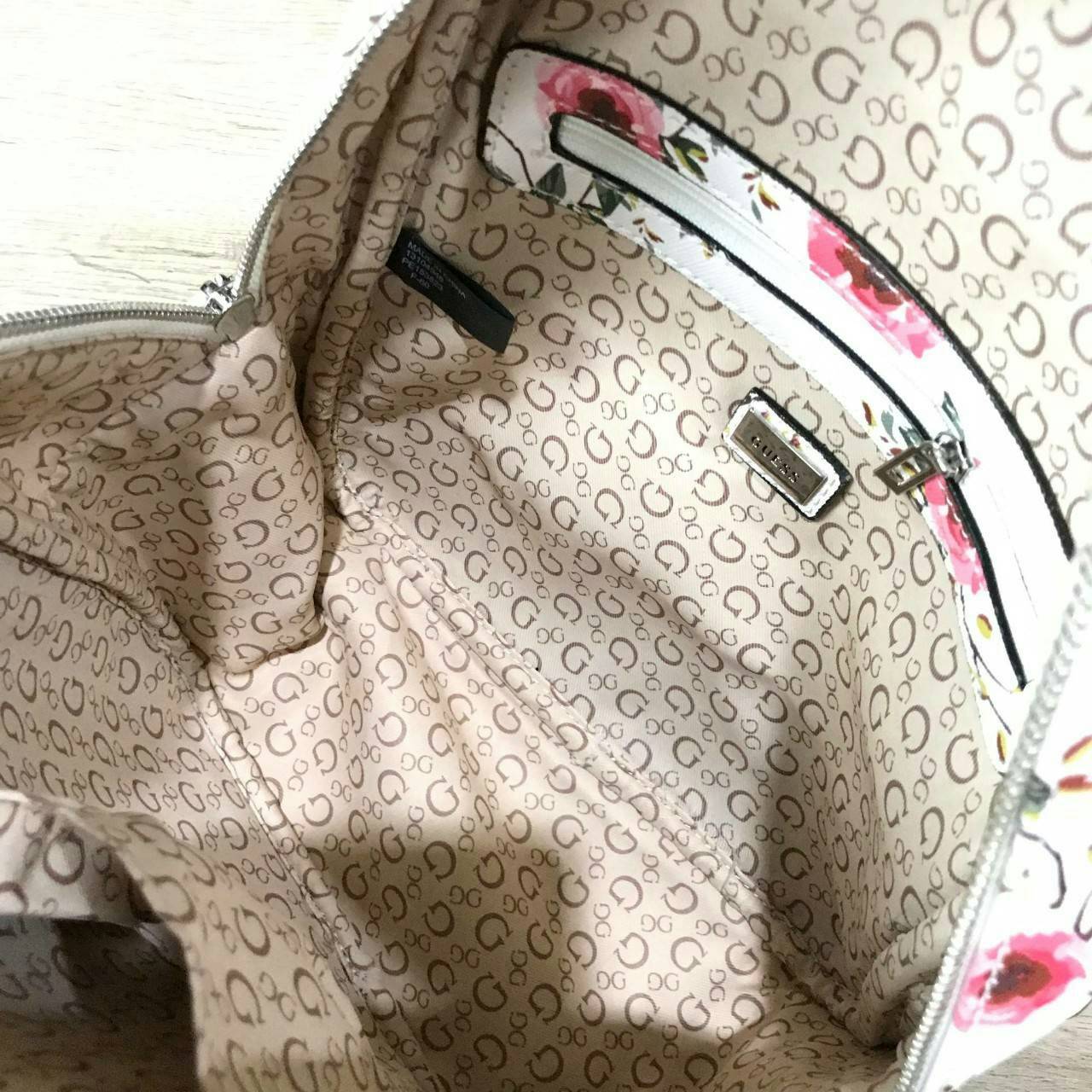 GUESS WOMAN'S FACTORY BACKPACK กระเป๋าเป้รุ่นใหม่ล่าสุดขนาดกำลังดีวัสดุหนังแกะสังเคราะห์พิมพ์ลายดอกไม้สวยน่ารัก น้ำหนักเบา มีหูหิ้วเเละสายสะพายหลังเลื่อนปรับได้ ด้านหน้ามีโลโก้และช่องซิป เปิดปิดด้วยซิปสะดวกใช้ ภายในกว้างและจุ ใส่ ipad กระเป๋าสตางค์ใบ