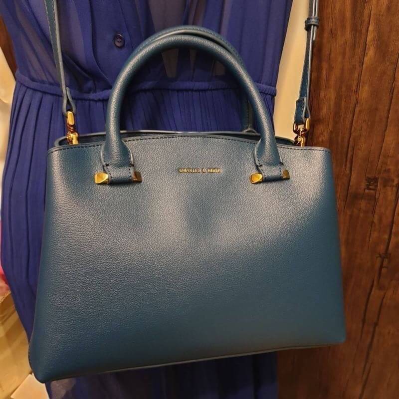 CHARLES & KEITH CLASSIC TOP HANDLE BAG กระเป๋าถือหรือสะพายใบใหญ่ ทรงแข็ง หนัง pu สวย ดีไซน์เรียบหรู ดูดี ด้านหน้าป้ายโลโก้แบบนูน ด้านหลังมีซ่องซิป 1 ช่อง เปิด-ปิดแบบกระดุมแม่เหล็ก ภายในมี 2 ช่องใหญ่ คั่นกลางด้วยช่องซิป มีหมุดรองรองฐานสี่มุม มาพร้อมสายสะพา