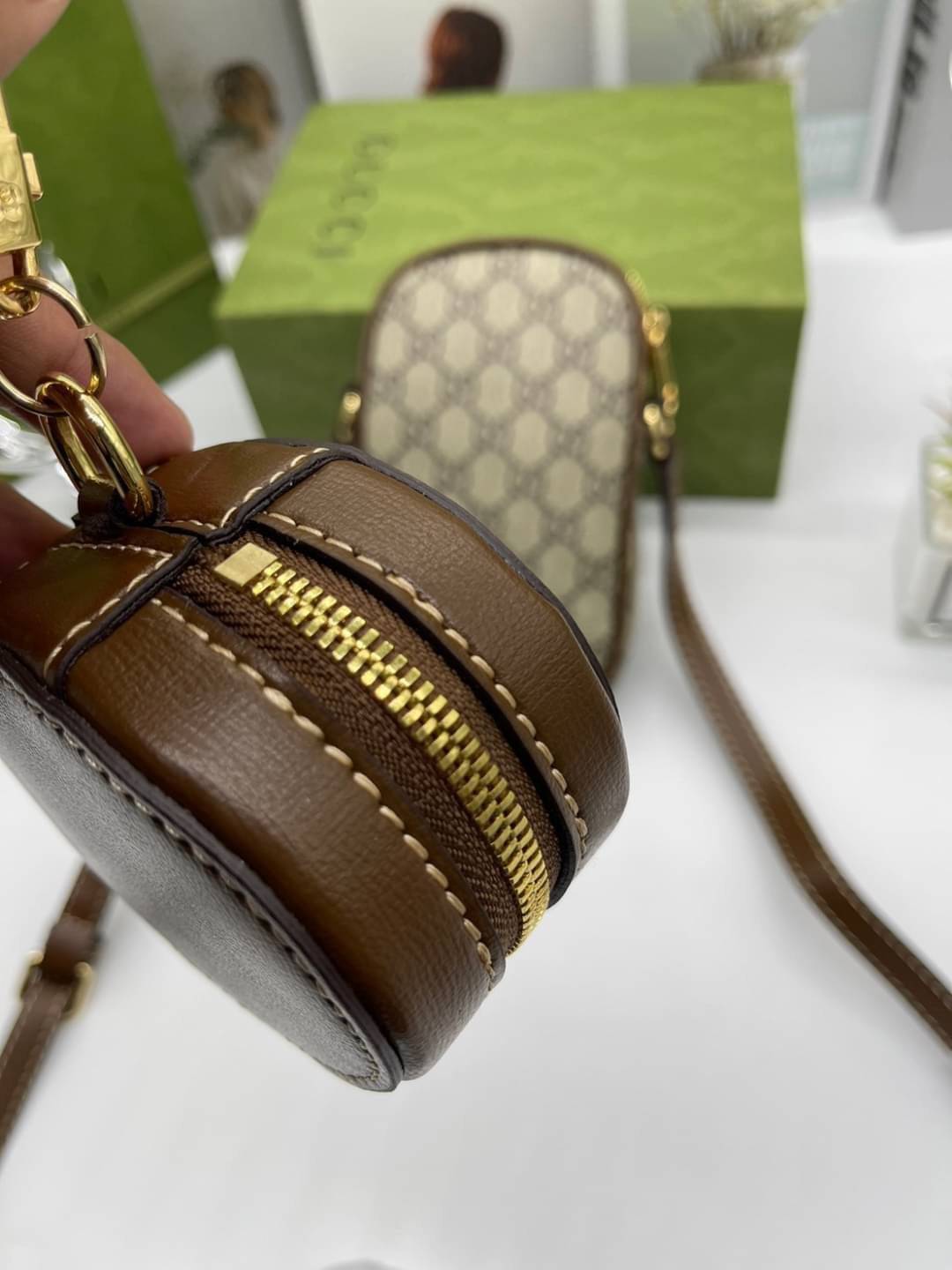 GUCCI Mini bag with Interlocking G / Gucci phone bag เกรดออริจินอล กระเป๋ามินิรังสรรค์จากผ้าแคนวาส Supreme ลายโมโนแกรมของแบรนด์สีเบจและสีน้ำตาลอีโบนี สัญลักษณ์ GG สไตล์นี้มอบความรู้สึกร่วมสมัยพร้อมกระเป๋าใส่ Apple AirPods ที่สามารถถอดออกได้