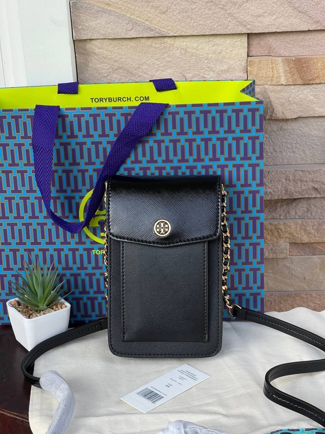 OUTLET 】Tory burch robinson mixed materials phone crossbody ไอเท็มหรูจากแบรนด์ดังอย่างTory burch อีกแบรนด์สุดคลาสสิกที่มีทั้งความเท่และความเรียบหรูลงตัว กับรูปทรงแบบมินิมอลสีเหลี่ยมมุมโค้งเรียบ ๆ ดีไซน์ฝาพับปิดกระเป๋าได้มิดชิด ยังมีลักษณะที่แนบกับตัวผู้ใช