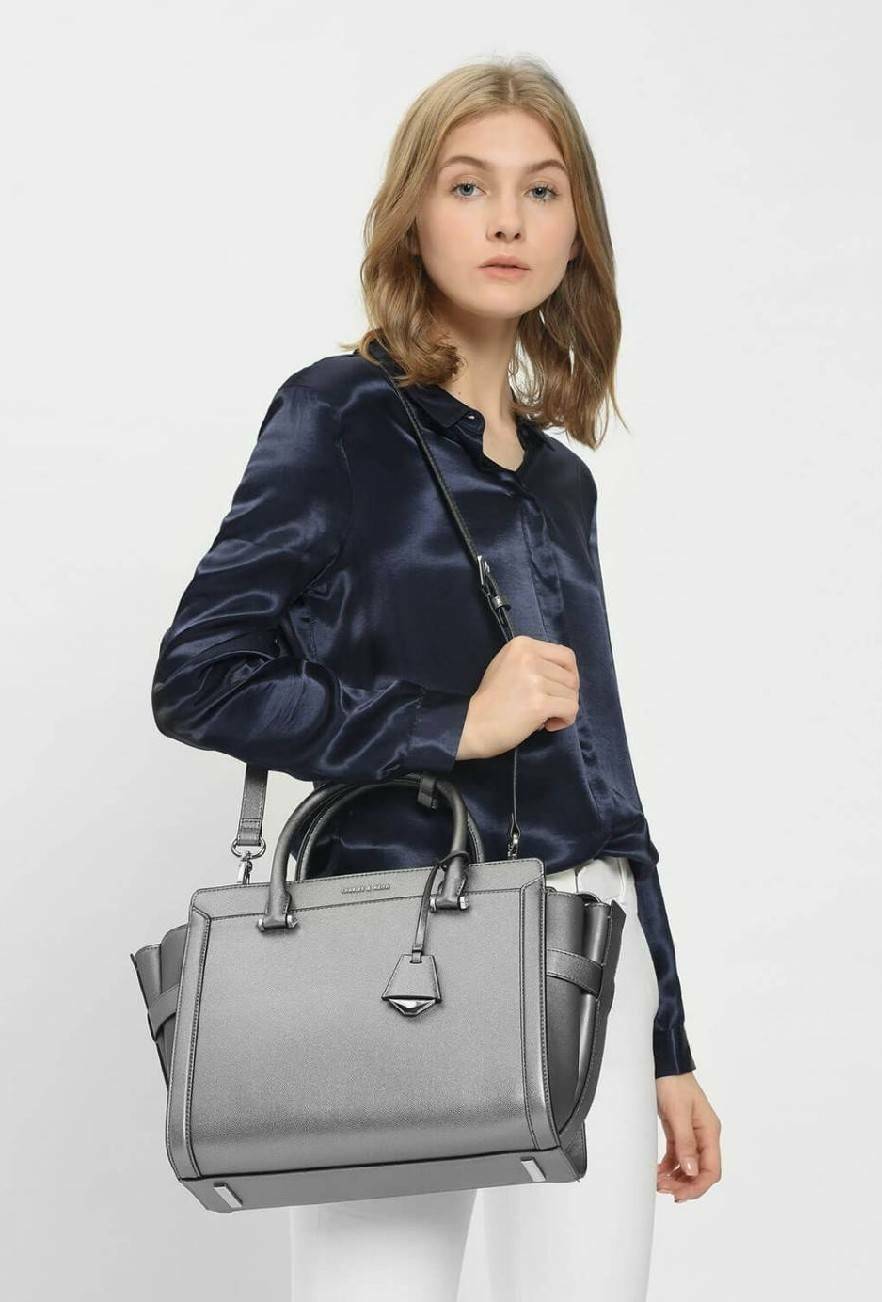 CHARLES & KEITH SAFFIANO TRAPEZE BAG กระเป๋าถือหรือสะพายรุ่นยอดนิยมดีไซน์สวยหรูวัสดุหนังคาเวียร์อยู่ทรง ด้านข้างเเต่งหนังช่องตัดดูมีดีเทล ด้านหน้ามีโลโก้ ด้านหลังมีช่องซิป เปิดปิดด้วยซิปหัวซิปแบรนด์ หูจับเเข็งแรง พับลงได้ พร้อมสายสะพายหนังปรับระดับได้ถอดไ