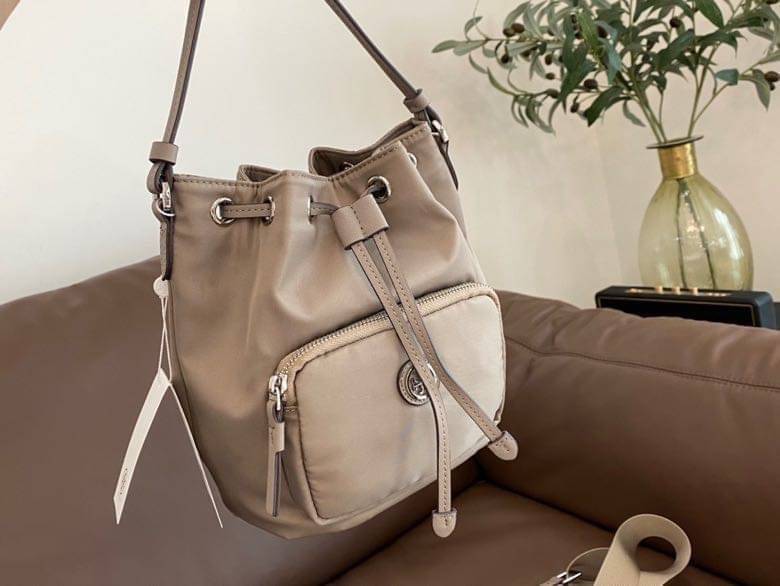 Tory Burch Virginia Nylon Bucket Bag / Tory Burch logo-plaque bucket bag กระเป๋าสะพายทรงบัคเก็ต เปิด-ปิดหนังรูดปากกระเป๋า มีหูหิ้วในตัว คล้องแขนเก๋ๆ ภายในเป็นช่องโล่ง มีช่องย่อย ใส่ของสำคัญจุกจิกได้ มีสายครอส จะสะพายไปไหนก็ได้ทุกโอกาส สวยเลิศทุกสี พร้อมส่