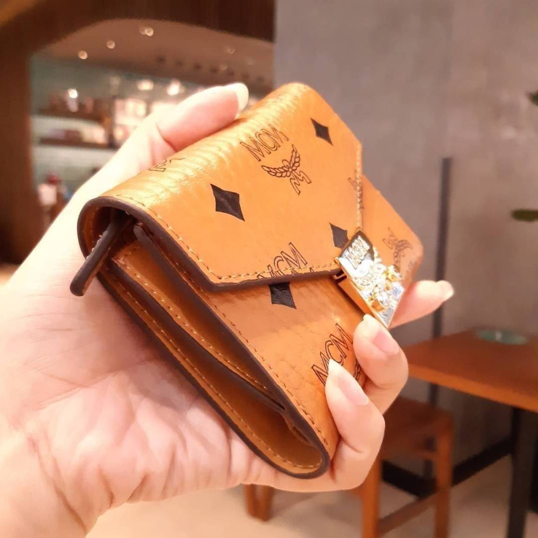 M.C.M PATRICIA THREE-FOLD WALLET IN VISETOS กระเป๋าสตางค์ใบเล็ก รุ่นฝาพับ unisex ใช้ได้ทั้งหนุ่มๆและสาวๆน้า ใช้งานง่าย ด้วยกระดุมโลโก้ พกพาง่าย วัสดุหนังแคนวาสคุณภาพดี ภายในเป็นหนังแท้ นิ่ม สวย ใส่บัตรได้เยอะ ใส่ธนบัตรได้ทุกชนิด ในช่องมีที่ใส่บัตรพิเศษภาย