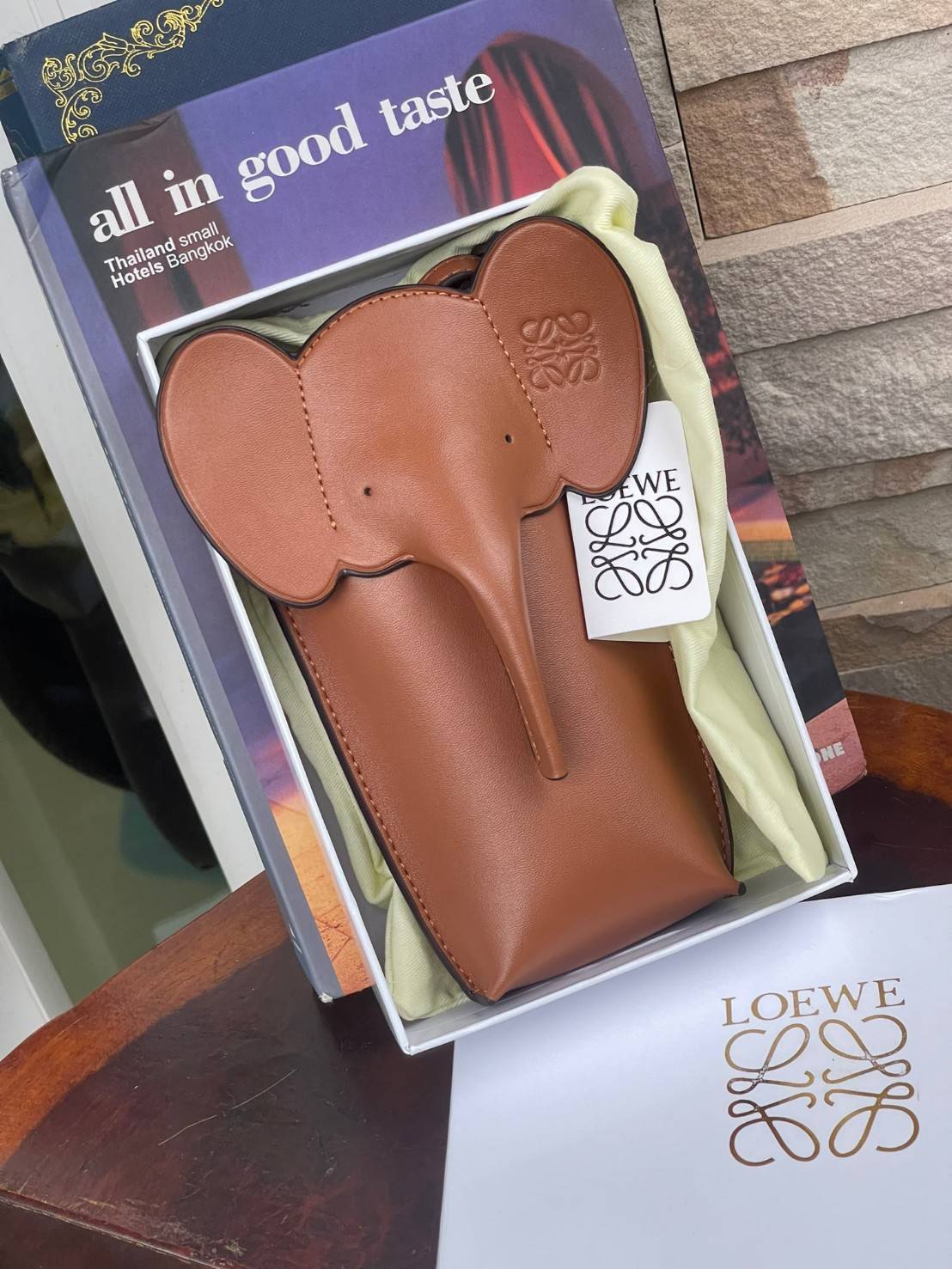 Loewe Leather Elephant Phone Holder แบรนด์หรูจากประเทศสเปนอย่าง โลเอเว่ (LOEWE) หลายๆคนคงนึกถึงกระเป๋ารูปทรงช้างขนาดเล็ก ที่เป็นเหมือนหนึ่งในซิกเนเจอร์ของแบรนด์ มีทั้งแบบสะพายข้าง แบบถือ รวมไปถึงในแบบเครื่องหนังชิ้นเล็กอย่างกระเป๋าใส่มือถือรุ่นนี้ ผลิตจาก