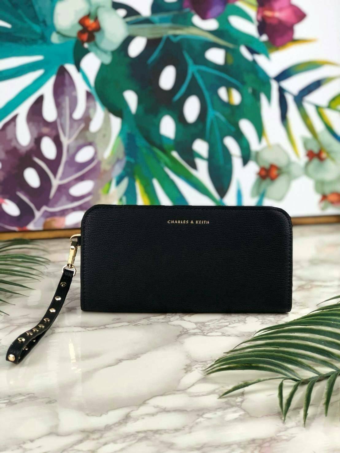 CHARLES & KEITH CLASSIC ZIP AROUND WALLET กระเป๋าเงินใบยาวซิปรอบ มีสายคล้องมีสีเข้ากระเป๋า 1 เส้น ใช้งานง่ายมากๆ คล้องมือก็เก๋ ด้านหน้าปั๊มโลโก้แบรนด์ เปิดปิดด้วยซิปรอบ ที่สายคล้องมือแต่งหมุดสีสวยเด่น ถอดสายได้ จุบัตรได้ 12 ใบ มีช่องซิปใส่เหรียญและช่องใส่