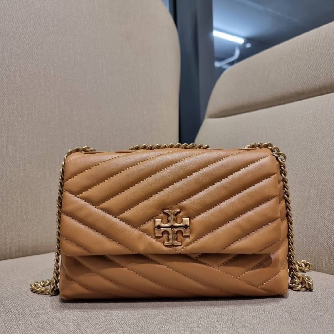 TORY BURCH KIRA CHEVRON CONVERTIBLE SHOULDER BAG (SMALL / MEDIUM) กระเป๋าสะพายรุ่นยอดฮิต ไซส์คลาสสิค ที่ใช้ยังไงก็ดูหรู ดีไซน์เฉพาะตัว วัสดุหนังแกะ สัมผัสนิ่ม เปิด-ปิดด้วยกระดุมแม่เหล็ก ภายในเป็นช่องโล่ง ใส่กระเป๋าสตางค์ มือถือ เครื่องสำอางค์ พาวเวอร์แบงค