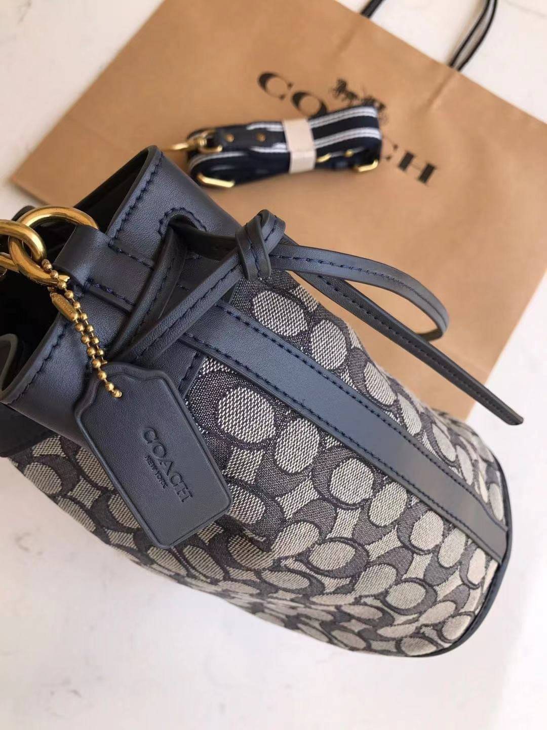 COACH FIELD BUCKET BAG IN SIGNATURE JACQUARD C3853 กระเป๋าสะพายทรงบัคเก็ต รุ่นใหม่ล่าสุด ดีไซน์ลายซิกเนเจอร์บนผ้า jacquard สวยคม เป็นเอกลักษณ์ไม่ซ้ำใคร มาพร้อมสายสะพายผ้าสปอร์ต และสายสั้นสำหรับคล้องแขนได้ สามารถรูดปิดปากกระเป๋าด้วยหนังรอบใบ เพิ่มดีเทลให้ต