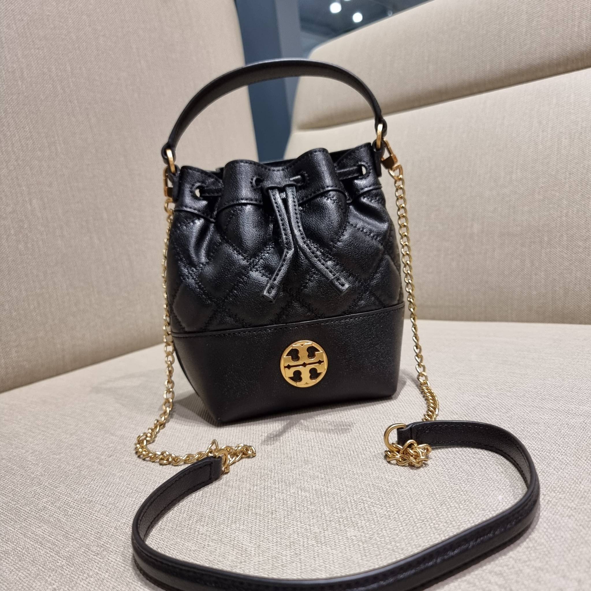 TORY BURCH WILLA MINI BUCKET BAG NEW ARRIVAL สุดปัง กระเป๋าสะพายทรงบัคเก็ต สวยผู้ดี โดดเด่นด้วยโลโก้สีทองดูหรู อัพลุคผู้ดี๊ผู้ดี วัสดุหนังแท้ ดีไซน์บุนวม เส้นคมดีเทลหรู เปิด-ปิดหนังรูดปากกระเป๋า มีหูหิ้วในตัว คล้องแขนเก๋ๆ ภายในเป็นช่องโล่ง มีช่องย่อย ใส่ข