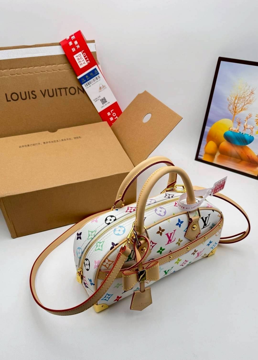 LV x TM Handbag East West Murakami กระเป๋าทรงโท้ทรุ่นท็อปฮิต กับดีไซน์ใหม่ต้อนรับฤดูร้อน โดดเด่นด้วยการตกแต่งลายพิมพ์ โทนสีสดใสสะดุดตา มาพร้อมพวงหนังห้อยรูปโบว์และแท็กปั้มแบรนด์ จับในตัวพร้อมสายสะพายข้าง รูปทรงสวยตลอดกาล