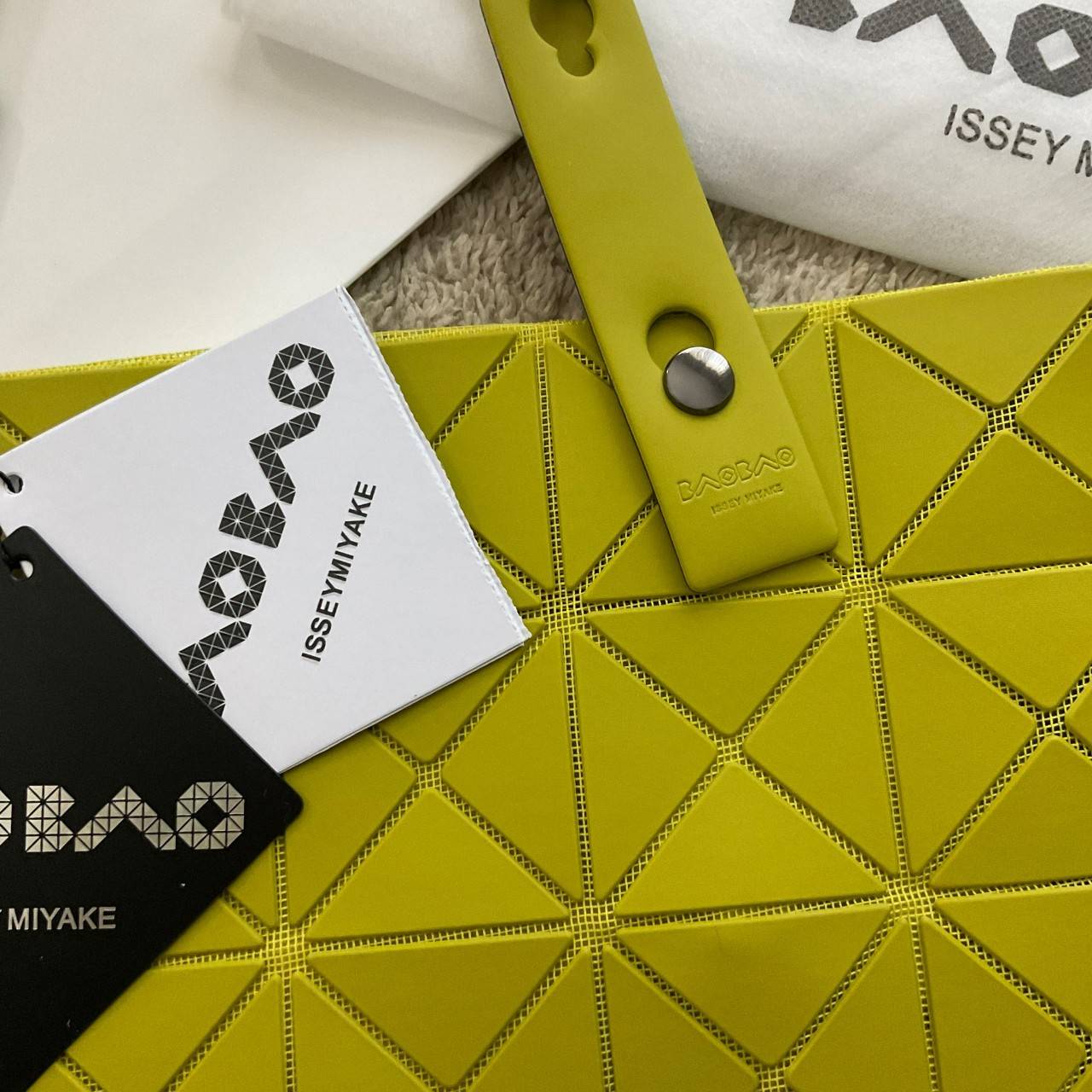 BAO BAO ISSEY MIYAKE LUCENT ONE-TONE กระเป๋าสะพายไหล่ ทรงโท้ท ใบใหญ่สวยมาก ปรับได้หลายทรงตามเอกลักษณ์เฉพาะของแบรนด์นี้ วัสดุ 100% POLYESTER PARTLY: SYMYHETIC LEATHER ด้านในใส่ของได้เยอะมาก ใส่ไอแพด สมุดโน้ตได้สบายเลย วัยทำงานหรือวัยนักศึกษา อย่างน้อยต้องม