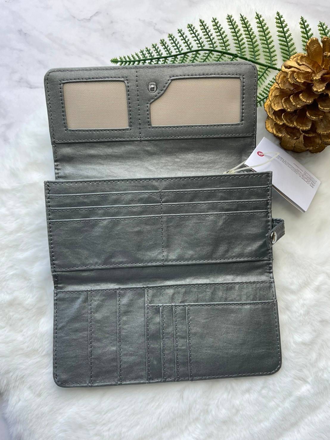 กระเป๋าสตางค์ยาว 3 พับตอน Kipling Brownie long tri-fold wallets กระเป๋าสตางค์ยาวแบบ3พับตอน วัสดุกันน้ำ เปิดปิดด้วยกระดุมแป๊ก มีช่องใส่ธนบัตรหลายช่อง ช่องเสียบการด์ได้ถึง13ช่องลายจุด และใส่รูปภาพได้อีก2ช่อง ช่องซิปใส่เหรียญ ช่องธนบัตร 3 ช่อง ที่จับหัวซิปปั