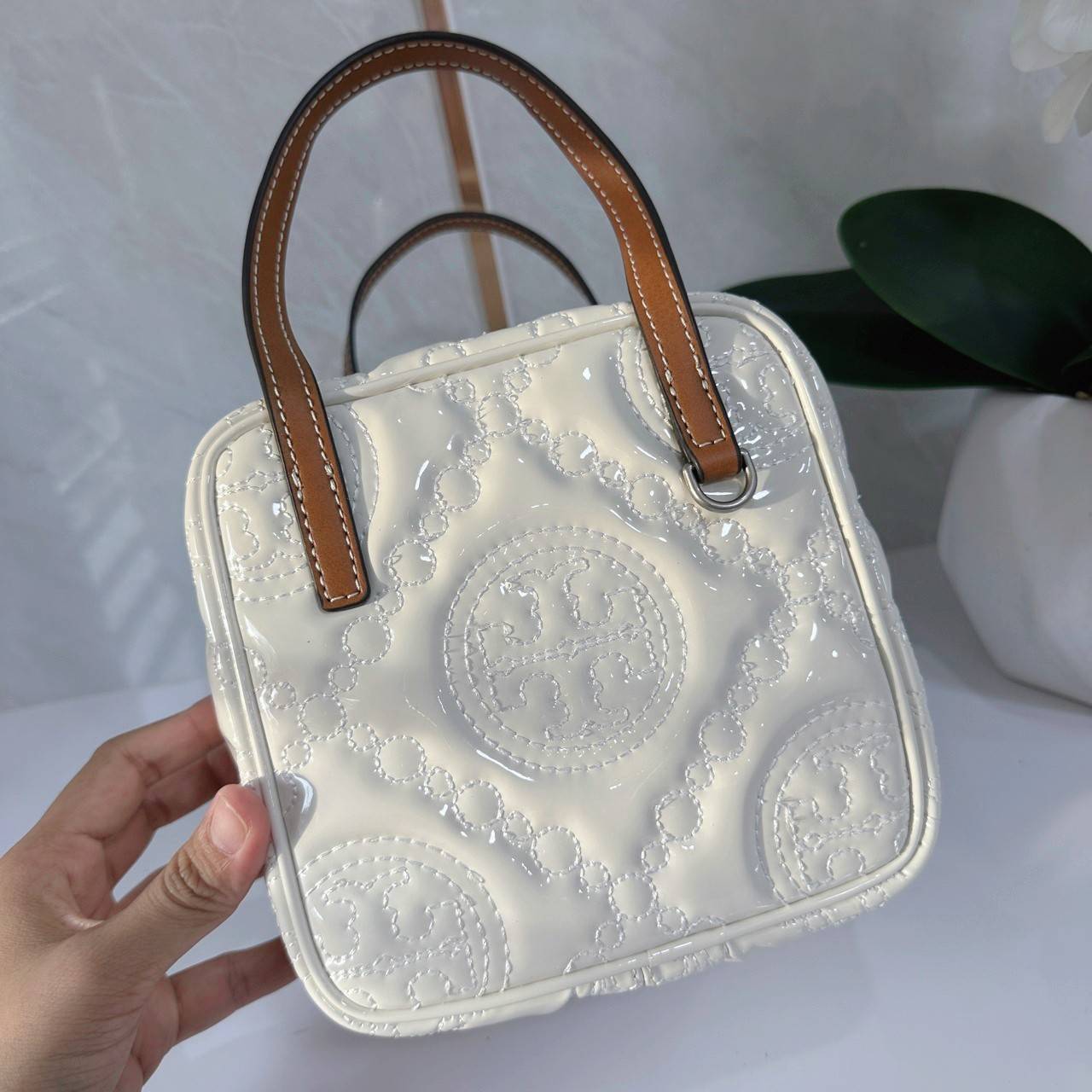 Tory Burch T Monogram Embroidered Patent Cube คอลเลคชั่นใหม่ รุ่นลิมิเต็ดรูปทรงใหม่ T Monogram สุดcube วัสดุหนังแท้ เปิด-ปิดด้วยซิป ภายในกว้าง มีช่องแยก 1 ช่อง สามารถใส่โทรศัพท์มือถือได้ทุกรุ่น สามารถถือหิ้วหรือสะพายได้ สายสามารถถอดและปรับระดับได้คะ