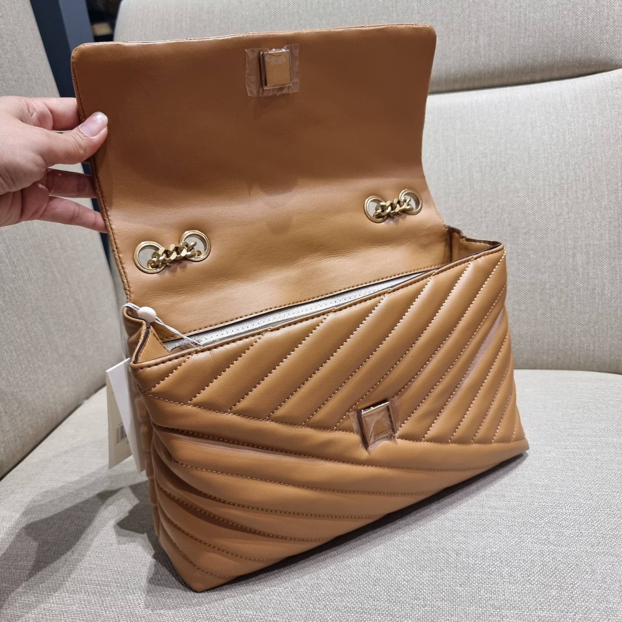 TORY BURCH KIRA CHEVRON CONVERTIBLE SHOULDER BAG กระเป๋าสะพายรุ่นยอดฮิต ไซส์ใหญ่จัดเต็มให้เน้นๆ ใช้ยังไงก็ดูหรู ดีไซน์เฉพาะตัว วัสดุหนังแกะ สัมผัสนิ่ม เปิด-ปิดด้วยกระดุมแม่เหล็ก ภายในเป็นช่องโล่ง แบ่งสัดส่วนไว้ดีมากๆ ใส่กระเป๋าสตางค์ มือถือ เครื่องสำอางค์