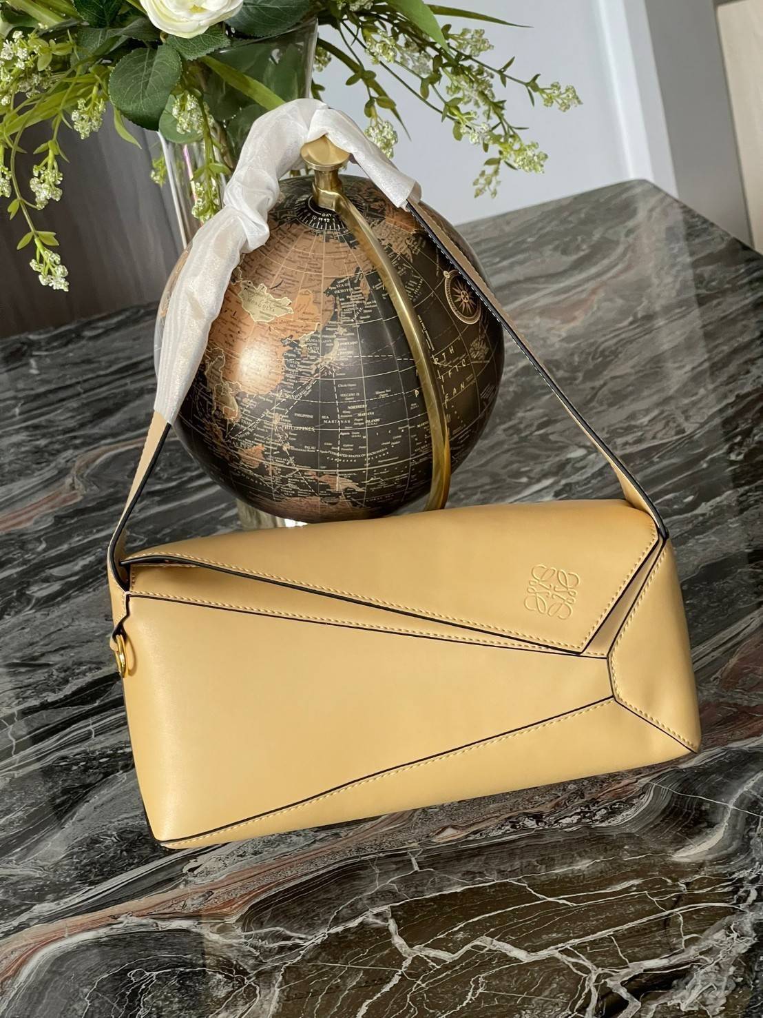 Loewe Puzzle Hobo bag กระเป๋ารุ่น Puzzle มีความพิเศษในหลายด้าน ไม่ว่าจะเป็นรูปทรงที่แปลกใหม่ มินิมอลด้วยโลโก้อนาแกรมแบบประทับ ดูหรู เป็นกระเป๋า Unisex ที่ไม่ว่าคุณจะเป็นผู้หญิงหรือผู้ชายก็ใช้งานได้ ลายกระเป๋าได้มาจากการนำหนังมาเย็บต่อกันทั้งหมด ถึงแม้ว่าข