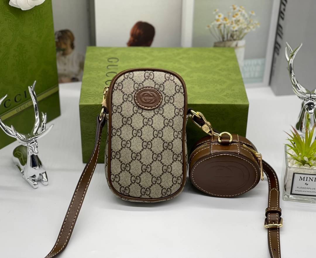 GUCCI Mini bag with Interlocking G / Gucci phone bag เกรดออริจินอล กระเป๋ามินิรังสรรค์จากผ้าแคนวาส Supreme ลายโมโนแกรมของแบรนด์สีเบจและสีน้ำตาลอีโบนี สัญลักษณ์ GG สไตล์นี้มอบความรู้สึกร่วมสมัยพร้อมกระเป๋าใส่ Apple AirPods ที่สามารถถอดออกได้