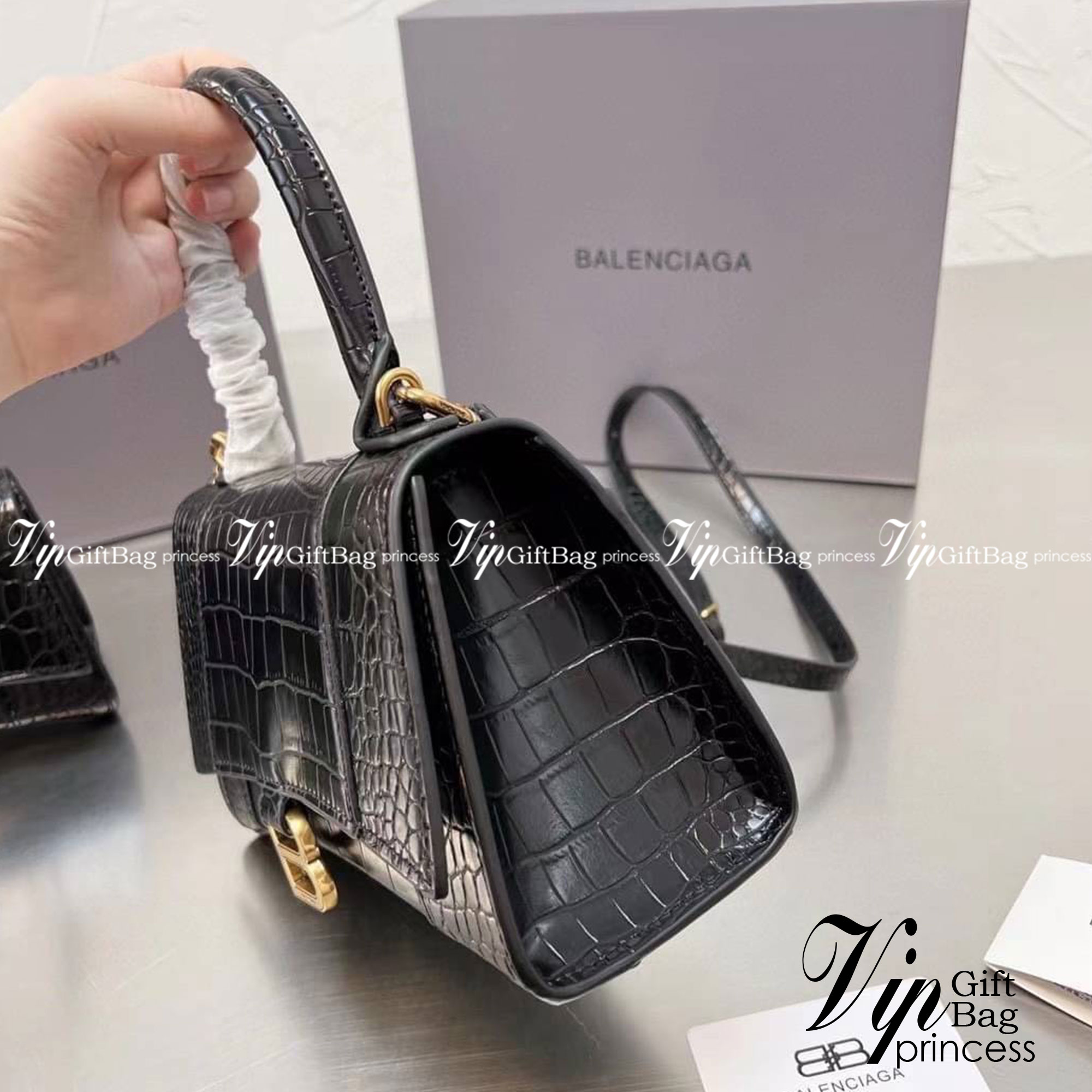 BALENCIAGA Hourglass BAG XS S / BALENCIAGA Hourglass Crocodile embossed calfskin กระเป๋าสะพายแบรนด์หรูซิกเนเจอร์ใบล่าสุด ที่มาพร้อมดีไซน์โดดเด่น มีความโฉบเฉี่ยว โค้งมนเหมือนพระจันทร์เสี้ยว เพิ่มความโดดเด่นสะดุดตาด้วยการตกแต่งอักษร B เมทัลลิก ที่เป็นเอกลัก