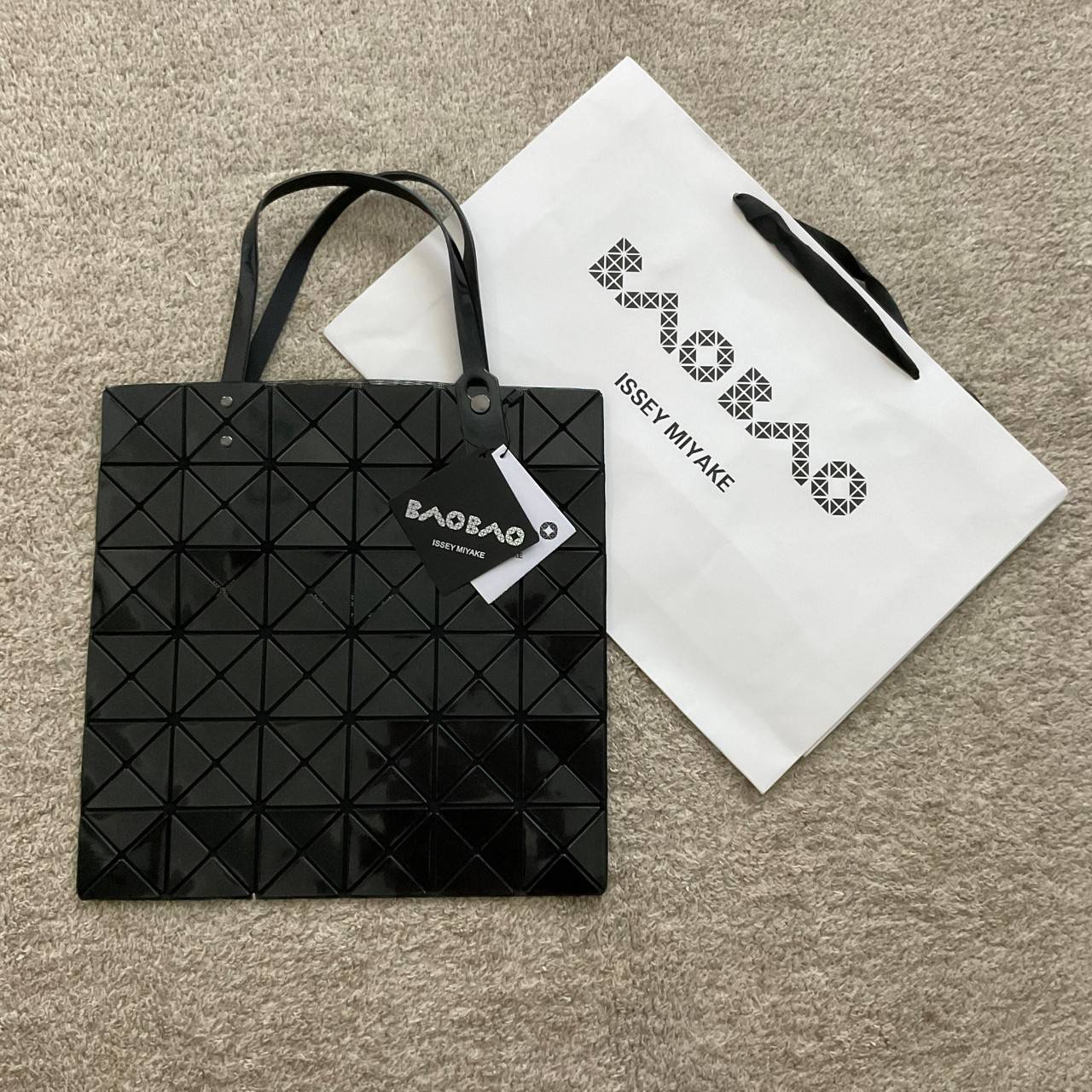 BAO BAO ISSEY MIYAKE TOTE BAG (6x6) กระเป๋าสะพายไหล่ ใบใหญ่ ทรงโท้ท จุดเด่นคือ ปรับได้หลายทรงตามเอกลักษณ์เฉพาะของแบรนด์นี้ ด้านในใส่ของได้เยอะมาก ใส่ไอแพด สมุดโน้ตได้สบายเลย พร้อมช่องซิปใส่ของให้อีกหนึ่งช่อง วัยทำงานหรือวัยนักศึกษา อย่างน้อยต้องมีแบรนด์นี