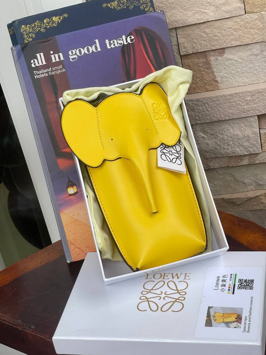 Loewe Leather Elephant Phone Holder แบรนด์หรูจากประเทศสเปนอย่าง โลเอเว่ (LOEWE) หลายๆคนคงนึกถึงกระเป๋ารูปทรงช้างขนาดเล็ก ที่เป็นเหมือนหนึ่งในซิกเนเจอร์ของแบรนด์ มีทั้งแบบสะพายข้าง แบบถือ รวมไปถึงในแบบเครื่องหนังชิ้นเล็กอย่างกระเป๋าใส่มือถือรุ่นนี้ ผลิตจาก