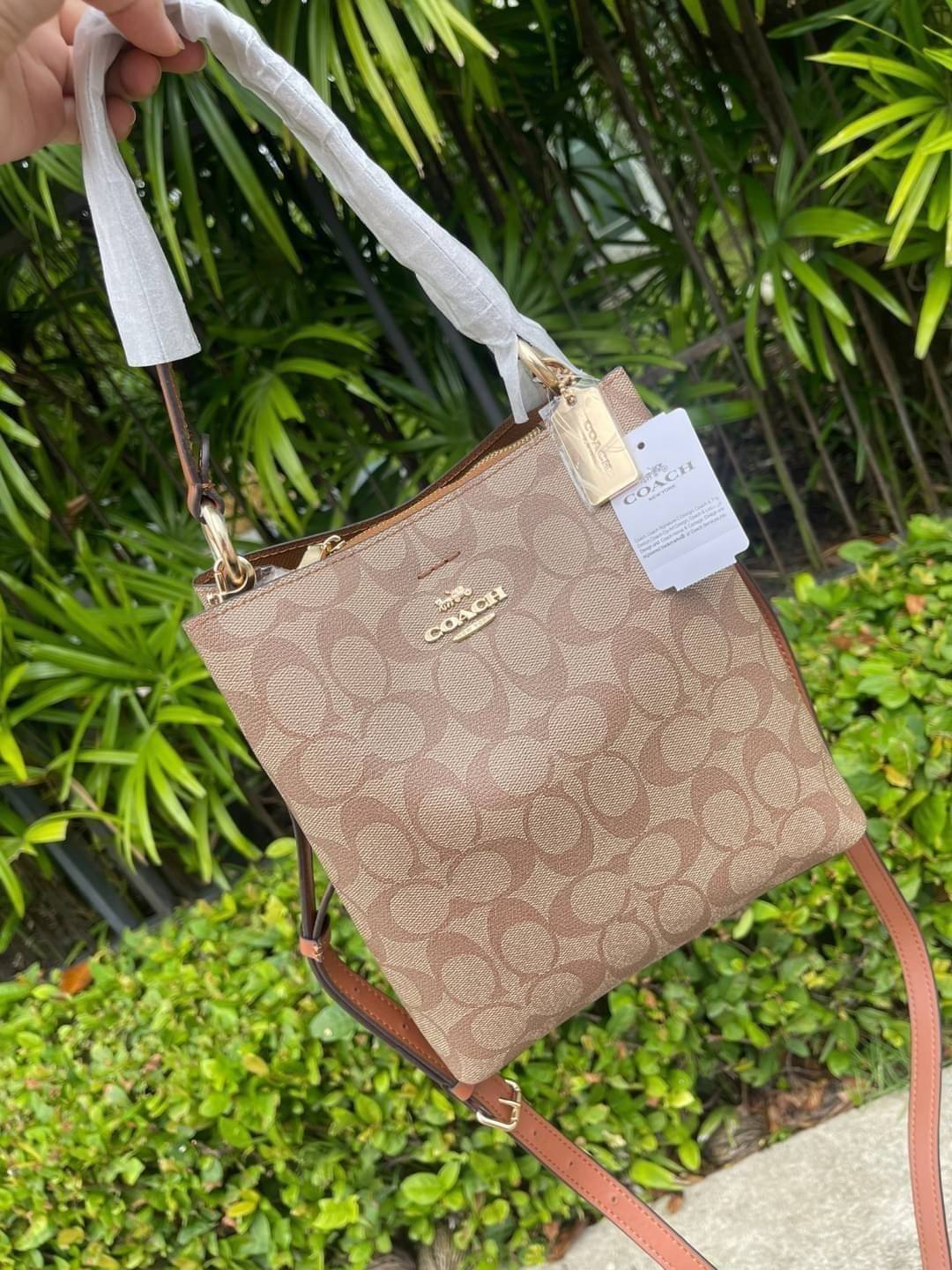 COACH SMALL TOWN BUCKET BAG IN SIGNATURE สำหรับสาวแฟชั่นที่ชอบรายละเอียดชิคๆ ดีไซน์สุดเก๋ แนะนำเลยสำหรับกระเป๋าทรงบักเก็ตใบนี้ เชื่อว่าสาว ๆ หลายคนชื่นชอบ เป็นไอเทมที่สามารถแมทช์ได้กับเสื้อหลากหลายสไตล์ บรรจุของได้เยอะโดยที่กระเป๋าไม่เสียทรง แบ่งช่องใช้งา