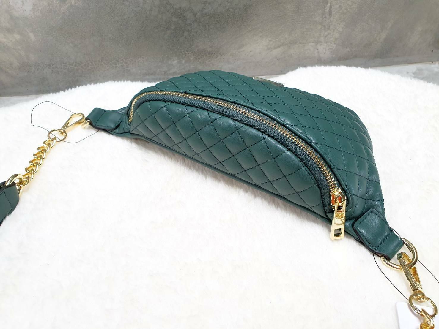 กระเป๋า Guess รุ่นนี้คาดเอว/คาดอก/สะพายข้างได้ครบทุกฟังก์ชั่น ด้านหน้าหนังเป็นลายตาราง ติดโลโก้แบรนด์รูปสามเหลี่ยมด้านหน้า เปิดปิดด้วยซิปยาว ด้านในเป็นช่องกว้างมีช่องซิปด้านใน ตัวกระเป๋าด้านหลังเป็นหนังเรียบ รุ่นนี้มีสายสะพายมา 2 เส้น เส้นแรกเป็นสายหนังปร