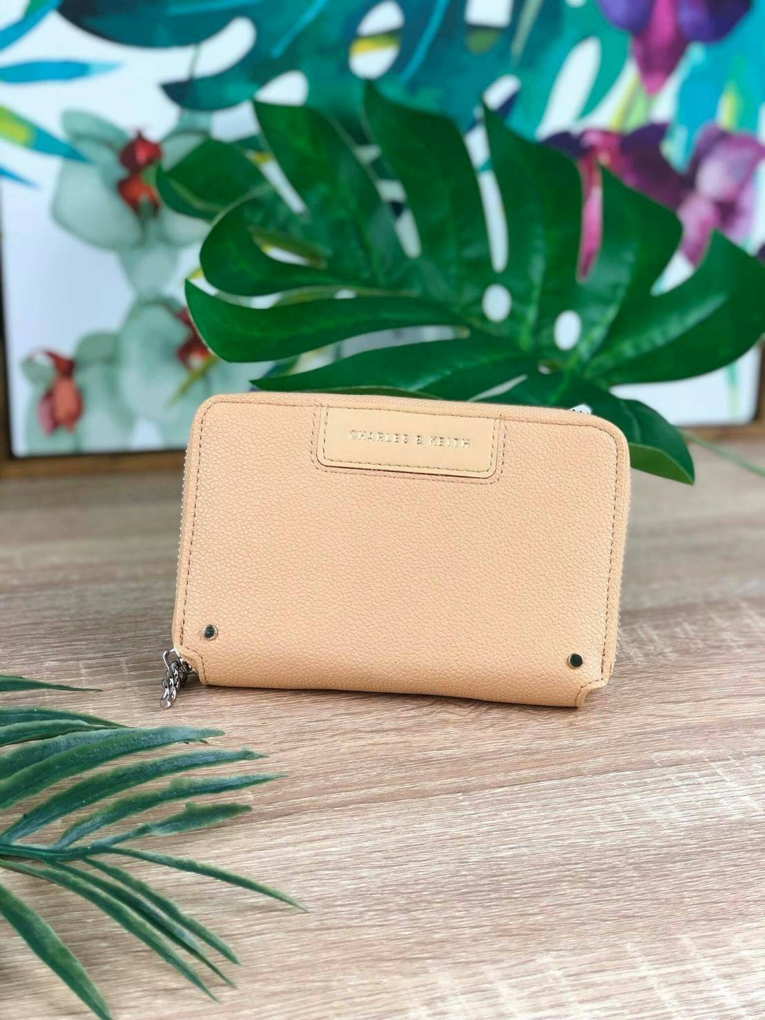 CHARLES & KEITH CHAIN ZIP WALLET กระเป๋าเงินซิปรอบใบกลาง หนังขึ้นลายสวยงาม ด้านหน้าปั๊มโลโก้แบรนด์ มีจุดเด่นที่ซิปเป็นห่วงโซ่เล็กๆน่ารัก ด้านในมีช่องซิปใส่เหรียญ ช่องบัตร 4 ใบและช่องใส่ธนบัตรตามยาว ใส่แบงค์พันได้ตามยาวเลยค่า ไว้ใช้กับกระเป๋าใบเล็กเหมาะมาก