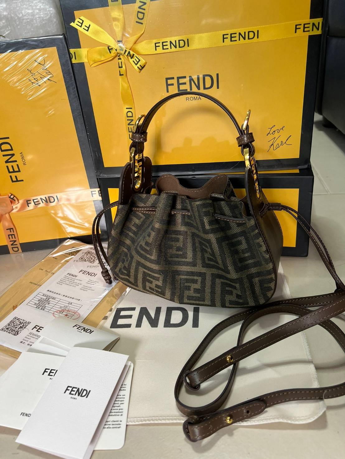 Fendi Pomodorino Brown FF Fabric Mini Bag กระเป๋าถือหรือสะพายไหล่ วัสดุผ้าโพลีเอสเตอร์ ลายแบรนด์ ผสมหนังวัวแท้ เปิดปิดด้วยเชือกรูด ทรงน่ารัก กะทัดรัด น้ำหนักเบา ใส่โทรศัพท์ i-phone+ ได้ สวยหรูลูกคุณหนูที่สุดเลยค่าใบนี้