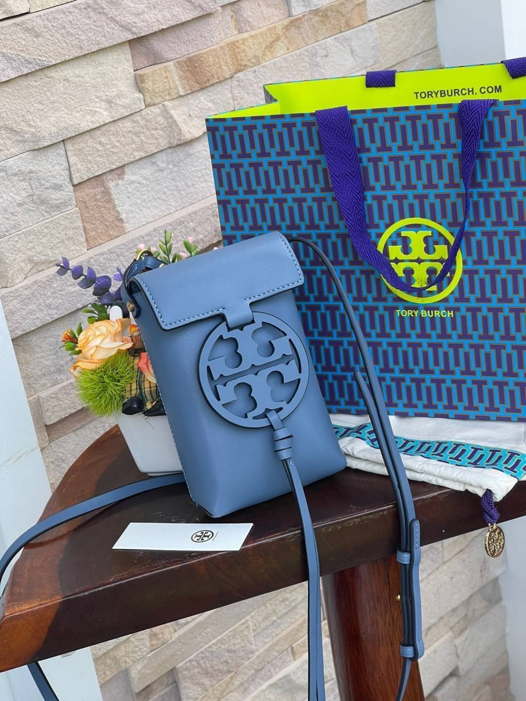 TORY BURCH MILLER METAL PHONE CROSSBODY อีกหนึ่งกระเป๋าใส่มือถือรุ่นฮิตที่เชื่อว่าหลาย ๆ คนต้องเคยเห็นผ่าน ๆ ตามาอย่างแน่นอน กับแบรนด์ Tory Burch ดีไซน์กระเป๋าทรงฝาพับแม่เหล็กใช้งานง่าย มาพร้อมดีเทล Logo สีเดียวกับเฉดสีของกระเป๋า แต่ยังมีความน่ารักด้วยทรง