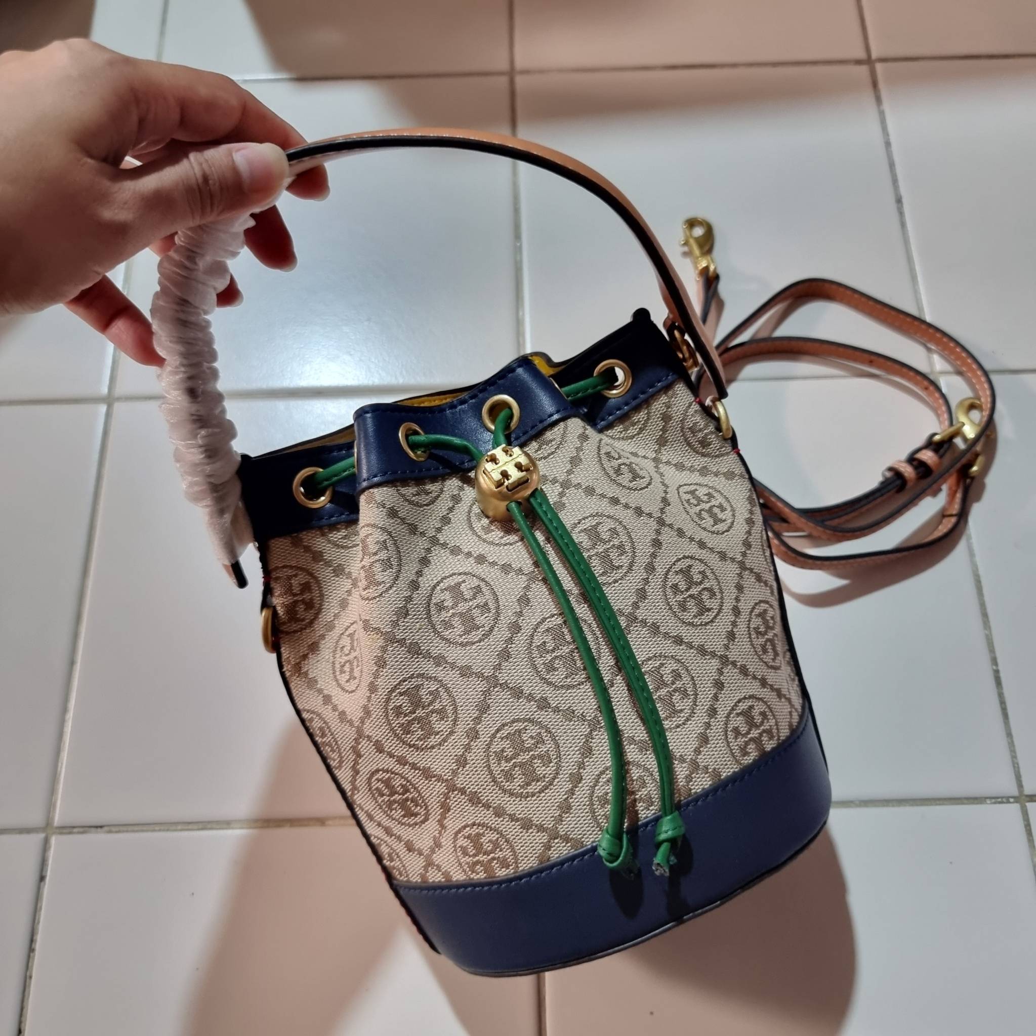 MINI : TORY BURCH T MONOGRAM COLOR-BLOCK JACQUARD MINI BUCKET BAG ใหม่ล่าสุด กับกระเป๋าบัคเก็ตทรงสวย ไซส์มินิ ในราคาน่ารัก โดดเด่นด้วยลวดลายเอกลักษณ์ ผสานลายคัลเลอร์บล็อค โทนสีตัดกันอย่างลงตัว ถักทอบนวัสดุ woven jacquard ลายคมชัด สลับส่วนของหนังแท้ ภายในเ