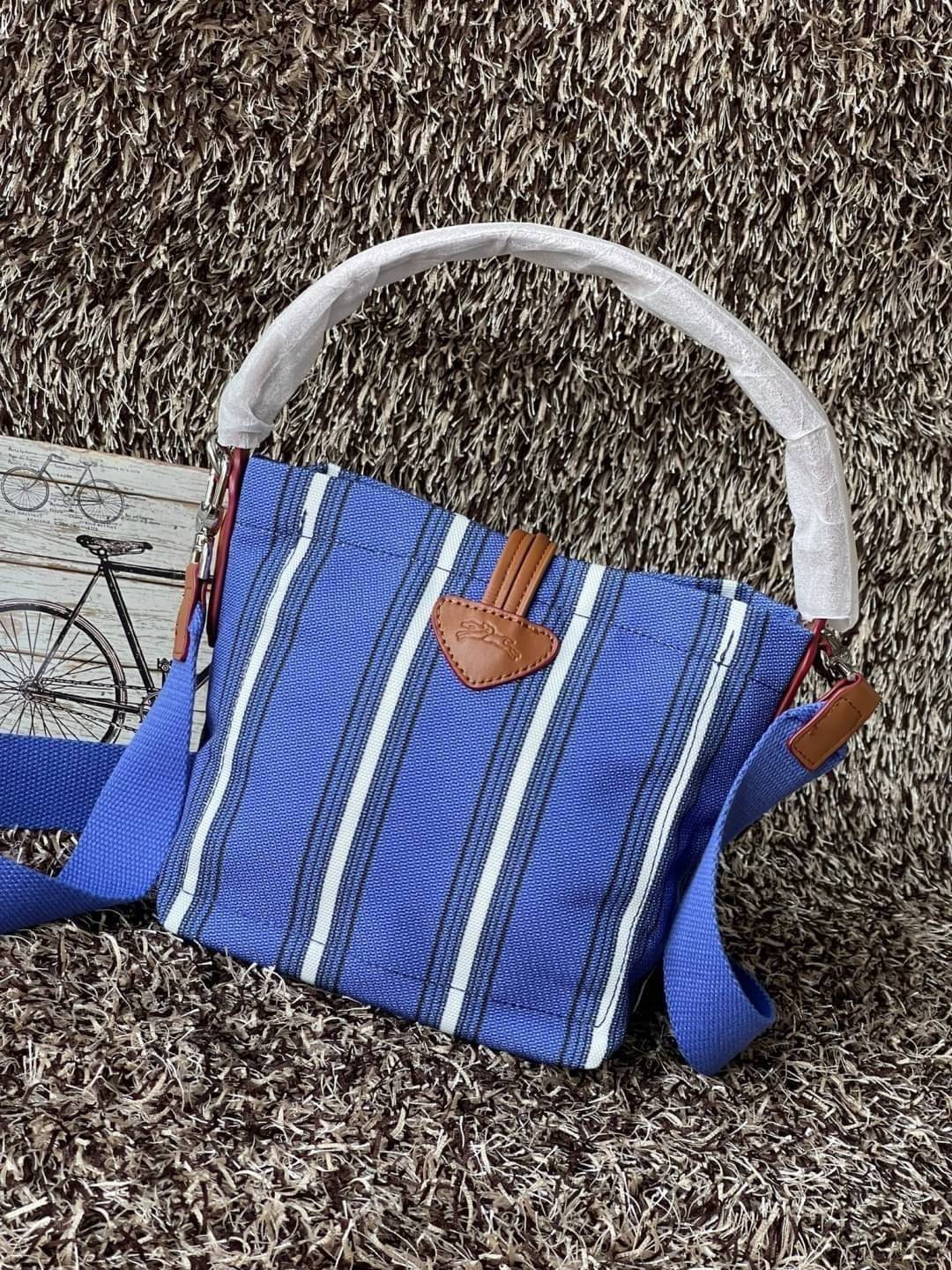 LONGCHAMP ROSEAU ESSENTIAL RAYÉ Bucket bag S - Blue สำหรับใครที่ต้องการกระเป๋าแบบใช้งานได้ในหลาย ๆ โอกาส สีสันกระเป๋าสามารถแมทช์ได้ง่ายกับเสื้อผ้า Longchamp รุ่นนี้สามารถตอบโจทย์ เป็นกระเป๋าที่ขนาดกำลังพอดี