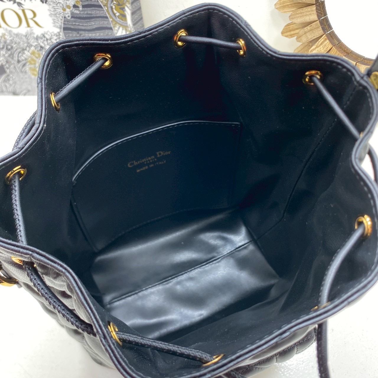 ORI หนังแท้ | Small Dior Caro bucket bag กระเป๋าทรงบักเก็ต รุ่นใหม่ประจำ Fall 2025 โดดเด่นด้วยดีไซน์ที่ทันสมัยและสง่างาม ได้รับการรังสรรค์ขึ้นจากหนังแกะสีดำเดินด้ายลาย Macrocannage พร้อมกับช่องเก็บของขนาดใหญ่แบบเชือกรูดปิด