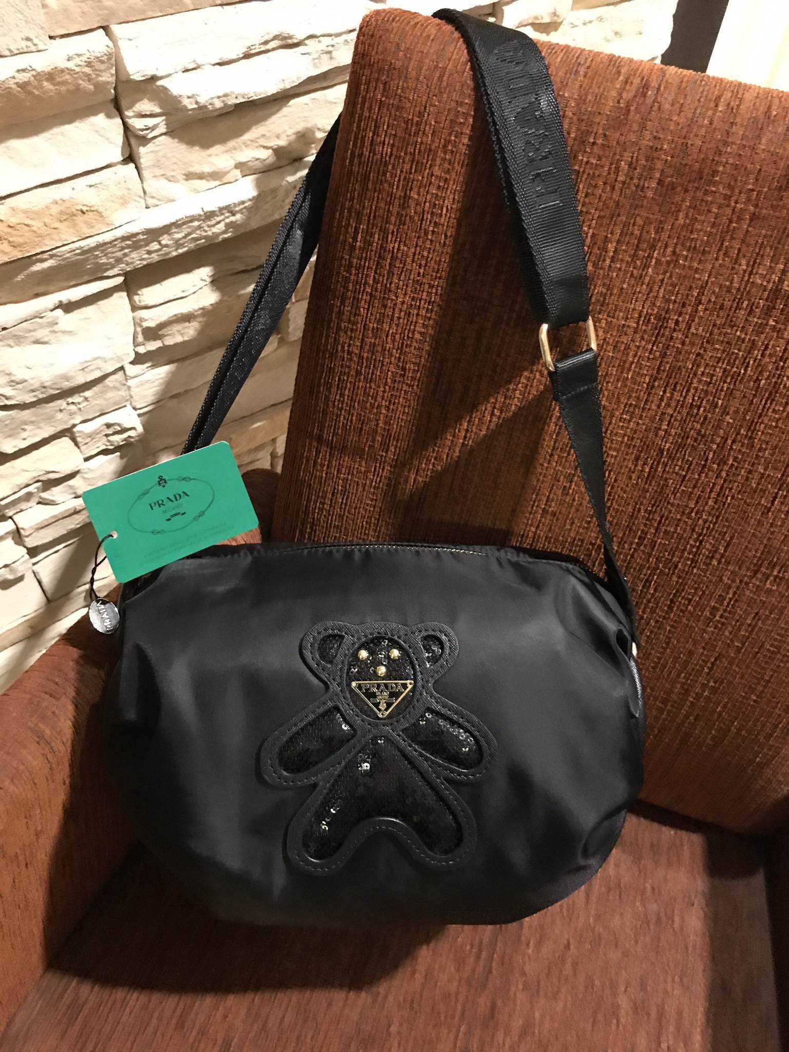 มาแล้วค้า! PRADA NYLON CROSSBODY BAG กระเป๋าสะพายพรีเมี่ยมกิ้ฟจากเคาน์เตอร์ต่างประเทศ Limited edition วัสดุ Nylon เนื้อหนาคุณภาพดีตามแบบฉบับแบรนด์ ขนาดใหญ่ จุได้เยอะ น้ำหนักเบา ด้านหน้าเป็นลายหมีปั๊กกลิ้ตเตอร์โลโก้แบรนด์อะไหล่ทองหรู ภายในซับ Polyester 100