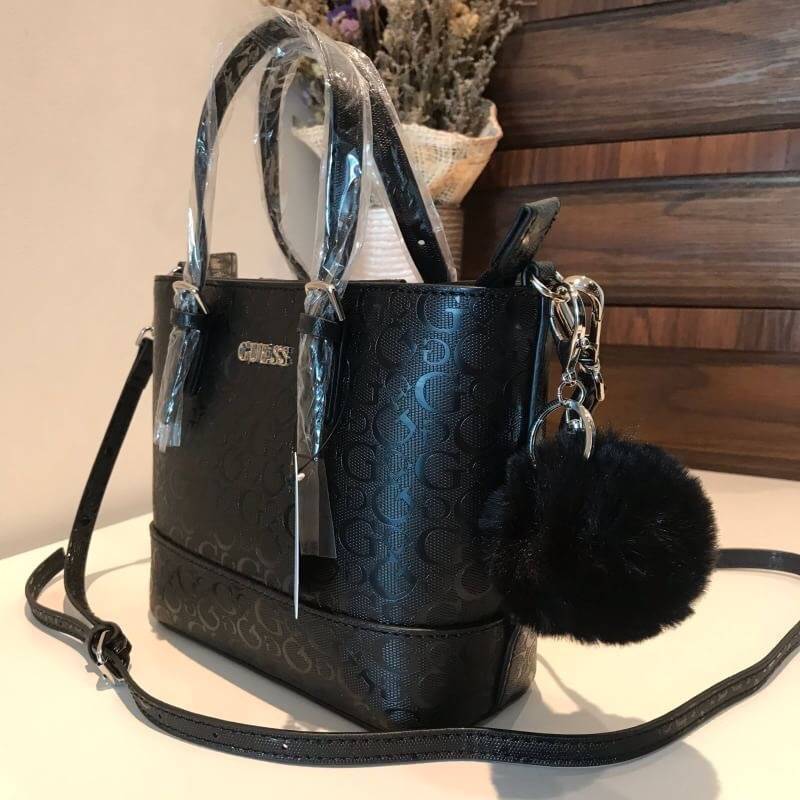 GUESS MINI CROSS BODY BAG กระเป๋าถือหรือสะพายรุ่นฮิตและขายดีที่สุดจาก GUESS FACTORY วัสดุหนังแก้วเงาสวยอยู่ทรง น้ำหนักเบา ด้านหน้าประดับด้วยโลโก้แบรนด์สุดหรูพร้อมปอมๆห้อยที่หูกระเป๋าถอดเเยกใช้ได้ เปิดปิดกระเป๋าด้วยซิปสะดวกใช้ ด้านในโล่งกว้างมีช่องซิปและช่