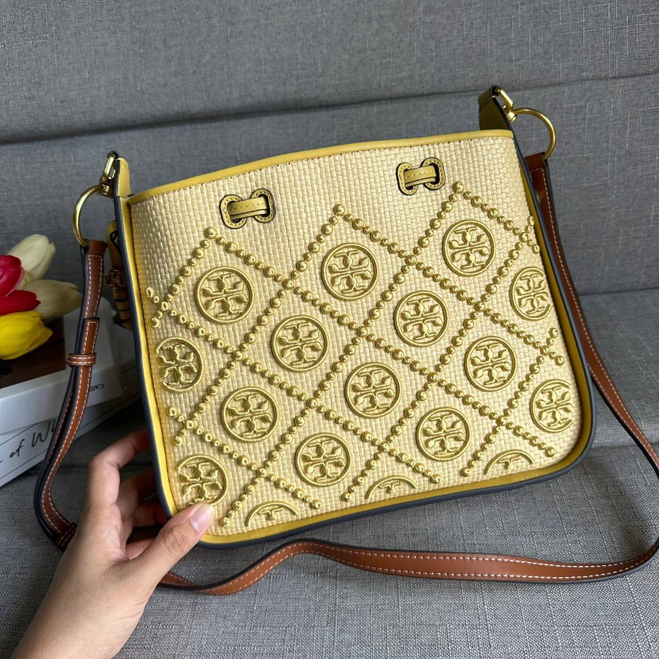 TORY BURCH T Monogram Straw Bell Bag กระเป๋าสะพายข้างรุ่นคลาสสิกที่ได้แรงบันดาลใจจากการควิลท์แบบดั้งเดิมของเพนซิลเวเนีย คอลเลกชันบ่งบอกถึงความมีสไตล์เหนือกาลเวลา รูปทรงเรียวโดดเด่น ปักทอลายแบรนด์อย่างสวยงาม เปิด ปิดด้วยเชือกรูด ด้านในช่องโล่งกว้าง ซับในผ้