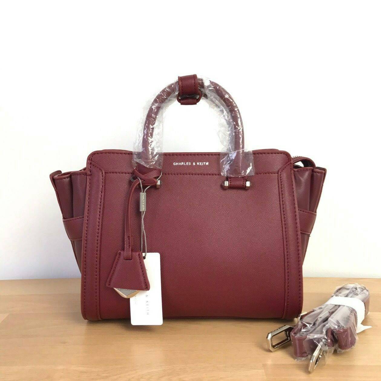 CHARLES & KEITH TRAPEZE BAG Best sellwr ! กระเป๋าถือหรือสะพายรุ่นยอดนิยมดีไซน์สวยหรูวัสดุหนัง คาเวียร์อยู่ทรง ด้านข้างเเต่งหนังช่องตัดดูมีดีเทล ด้านหน้าสกรีนโลโก้ ด้านหลังมีช่องซิป เปิดปิดด้วยซิปหัวซิป ปัํ๊มโลโก้ หูจับเเข็งแรง พับลงได้ พร้อมสายสะพายหนังปร