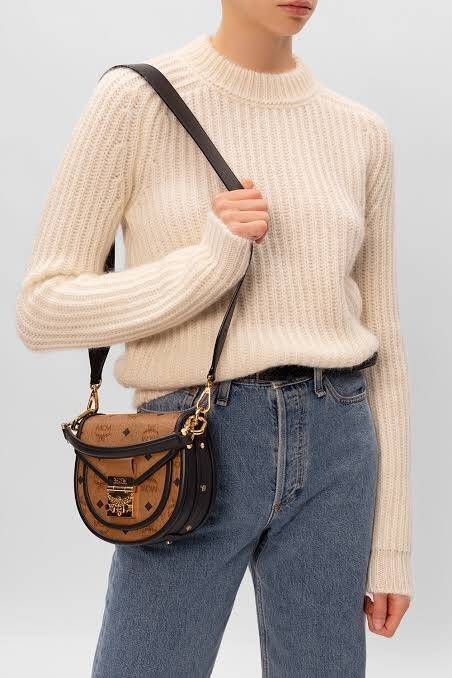 M.C.M MINI PATRICIA SHOULDER BAG IN VISETOS LEATHER BLOCK อัพเลเวลกระเป๋าของคุณด้วยไอเท็มนี้ไปเลยจ้า กระเป๋าสะพายทรง saddle ที่เก๋ไม่ซ้ำใคร ดีไซน์ขอบสีดำเพิ่มความยูนิค สวยสะดุดตา วัสดุหนังแคนวาสคุณภาพดี มาพร้อมสายสะพายหนังสีดำเรียบ และหูจับในตัว ทำให้ใช้ง
