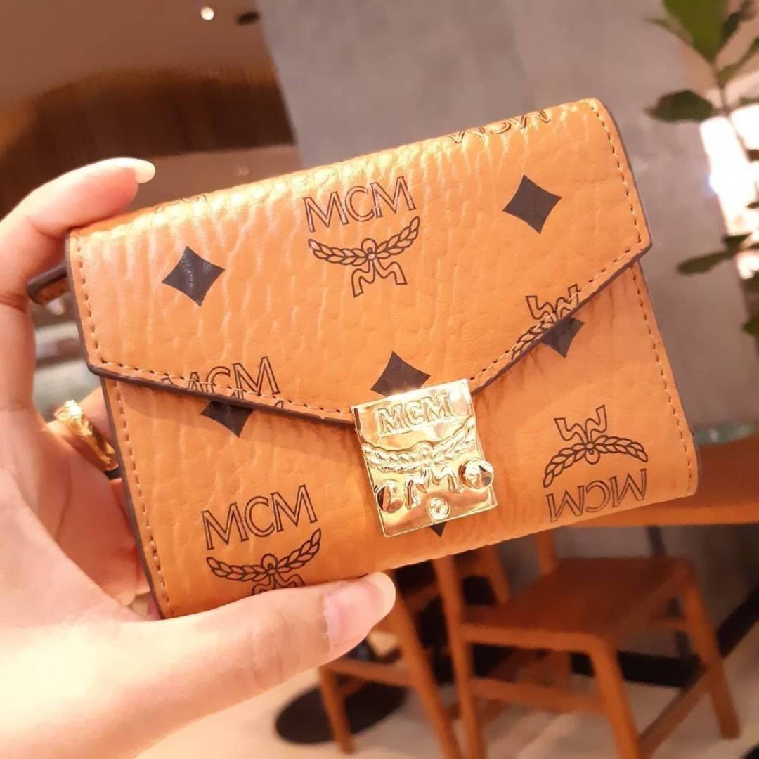 M.C.M PATRICIA THREE-FOLD WALLET IN VISETOS กระเป๋าสตางค์ใบเล็ก รุ่นฝาพับ unisex ใช้ได้ทั้งหนุ่มๆและสาวๆน้า ใช้งานง่าย ด้วยกระดุมโลโก้ พกพาง่าย วัสดุหนังแคนวาสคุณภาพดี ภายในเป็นหนังแท้ นิ่ม สวย ใส่บัตรได้เยอะ ใส่ธนบัตรได้ทุกชนิด ในช่องมีที่ใส่บัตรพิเศษภาย