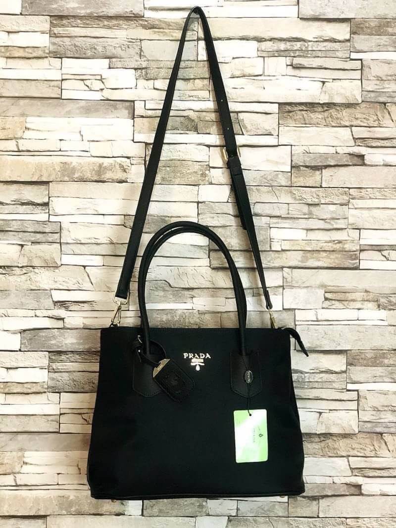 PRADA NYLON BAG Limited edition พรีเมี่ยมกิ้ฟจากเคาน์เตอร์แบรนด์ต่างประเทศ วัสดุ Nylon เนื้อหนาคุณภาพดีตามแบบฉบับแบรนด์ ด้านหน้าประดับทองโลโก้หรู ด้านข้างมีกระดุมปรับขยายได้ หูจับหนังแข็งแรง พร้อมสายสะพายยาวปรับระดับได้ มีหมุดรองฐานกันรอยสี่มุม ภายใน Poly