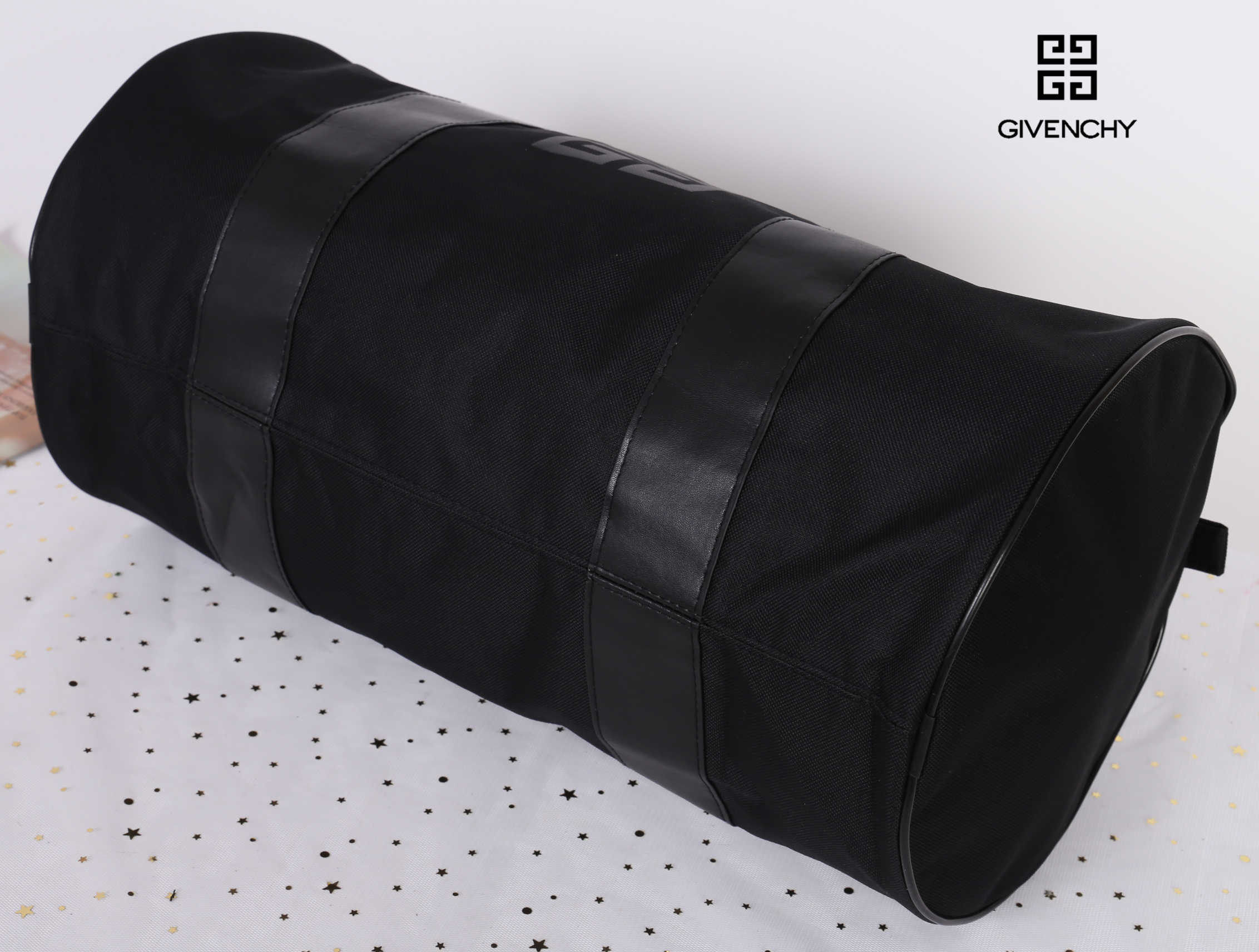 Givenchy Black Oxford Fabric Travel Bag สินค้าเป็นของใหม่ จากเค้าเตอร์เครื่องสำอาง/น้ำหอมของแบรนด์ กระเป๋าใบใหญ่สีดำ ทำจากผ้า Oxford สามารถกันน้ำได้ระดับนึง ด้านในบุด้วยผ้าซับสีดำอีกชั้น รุ่นนี้เป็นทรงกระบอก ตัวสายสะพายไหล่ทำจากหนัง แข็งแรงและทนทาน ใช้เป็