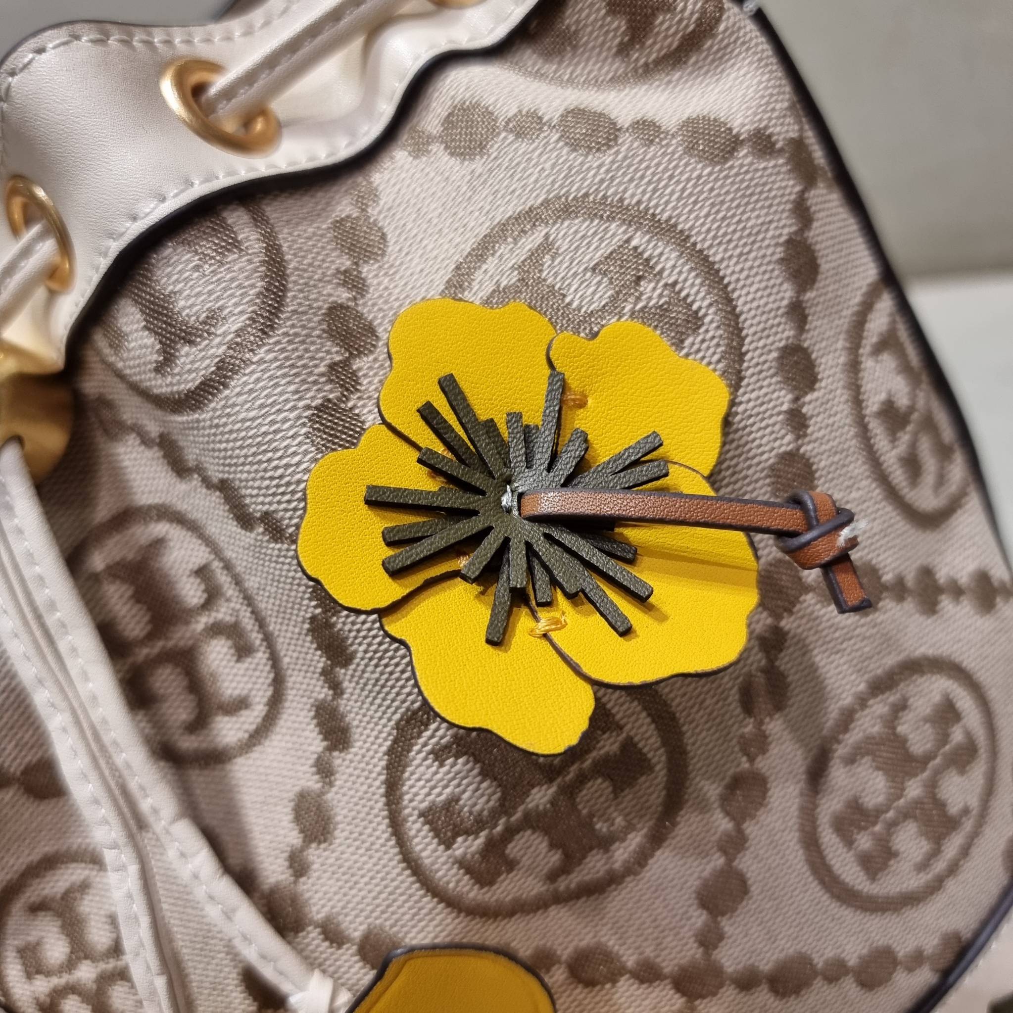 TORY BURCH T MONOGRAM FLORAL BUCKET BAG คอลเลคชั่นใหม่ พร้อมเสิร์ฟความสวยให้ถึงบ้าน!! กระเป๋าบัคเก็ตทรงยอดนิยม ดีไซน์ใหม่ล่าสุด สไตล์งานคราฟ มีลูกเล่นประดับดอกไม้กับตัวกระเป๋า และตัวรูดสาย วัสดุผ้า jacquard ตัดสลับหนังแท้ หูจับและขอบกระเป๋าตกแต่งลายสานสวย