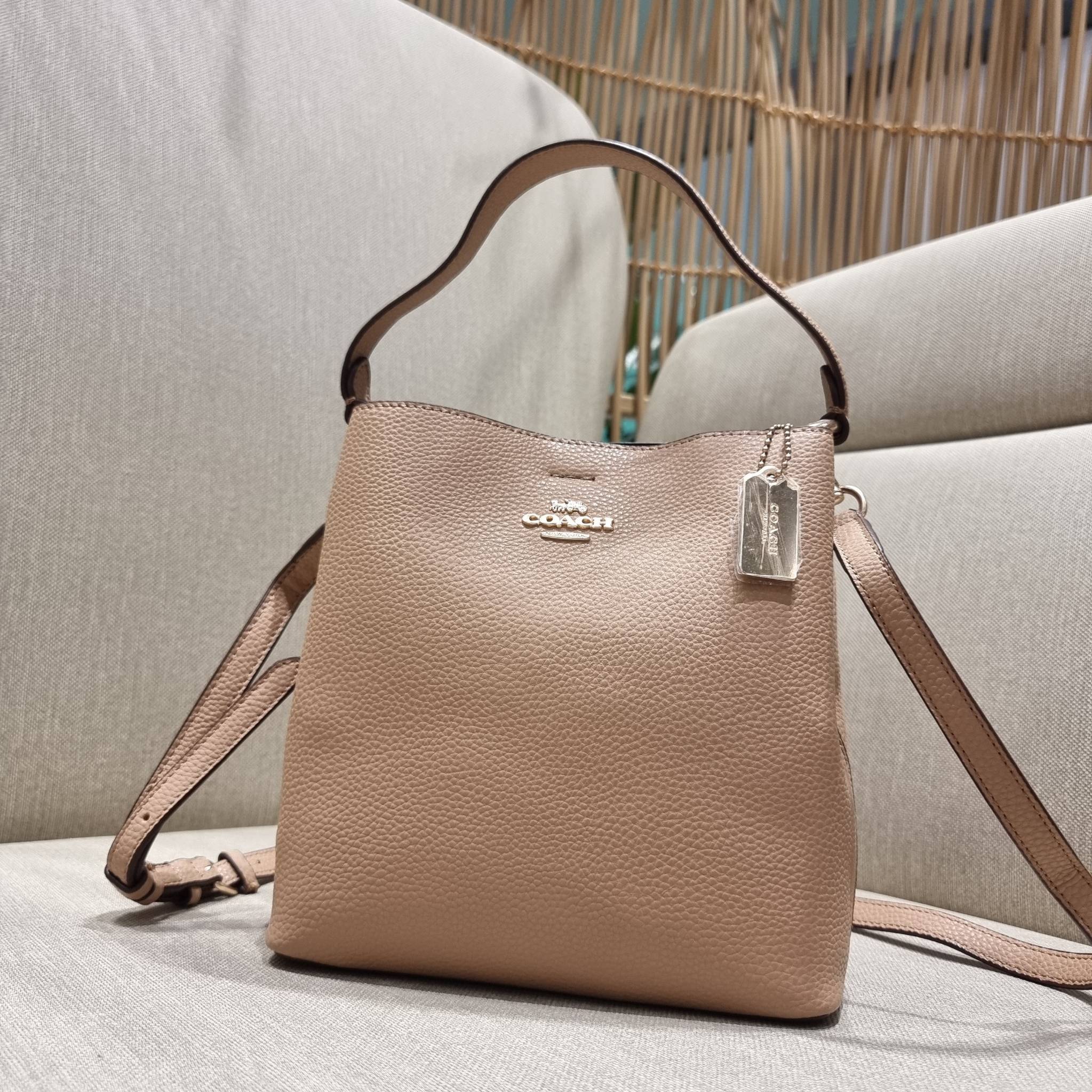 COACH 1011 SMALL TOWN BUCKET BAG รุ่นยอดนิยมใบเล็ก กระเป๋าทรงบัคเก็ต สีคลาสสิคเรียบหรู ตัดกับโลโก้สีทองดูโดดเด่น วัสดุหนัง pepble สวยคมทุกมุมจริงๆ!! เปิด-ปิดด้วยกระดุมแม่เหล็กทั้ง 2 ฝั่ง ภายในเป็นช่องโล่ง มาพร้อมสายสะพายปรับได้ตามตัว ขนาดใบนี้กำลังสวย สะพ