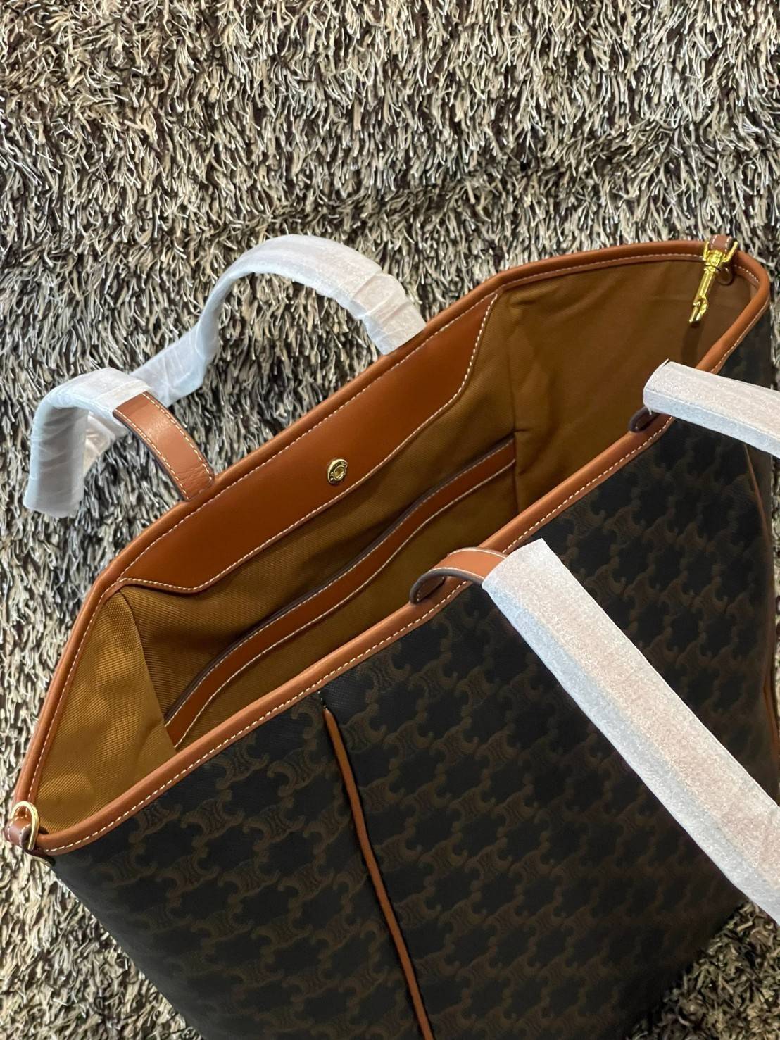 Celine Medium shopping bag in Triomphe canvas มาในรูปแบบ กระเป๋า Shopping Bag ใบสวยสง่า เป็นกระเป๋าดีไซน์เรียบง่าย แมตช์ได้กับทุกชุด ผลิตจากผ้าแคนวาสชนิดพิเศษซึ่งโดดเด่นด้วยลายเอกลักษณ์ของ Triompe เป็นใบที่เหมาะกับการใช้ประจำวันเป็นอย่างมาก ด้วยรูปทรงสี่เ