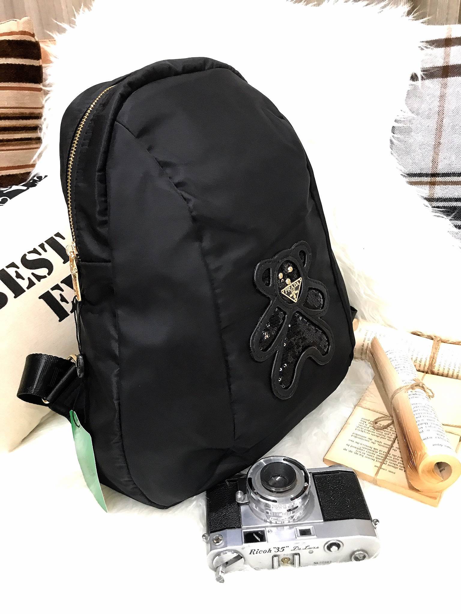 Don't Miss! PRADA NYLON BACKPACK กระเป๋าสะพายเป้ พรีเมี่ยมกิ้ฟจากเคาน์เตอร์ต่างประเทศรุ่น Limited edition ที่ฮ๊อตสุดๆ วัสดุเป็น Nylon เนื้อหนาคุณภาพดีตามแบบฉบับของแบรนด์ ขนาดกำลังดี น้ำหนักเบา ด้านหน้าเป็นลายหมีปั๊กกลิ้ตเตอร์โลโก้แบรนด์อะไหล่ทองหรู ภ