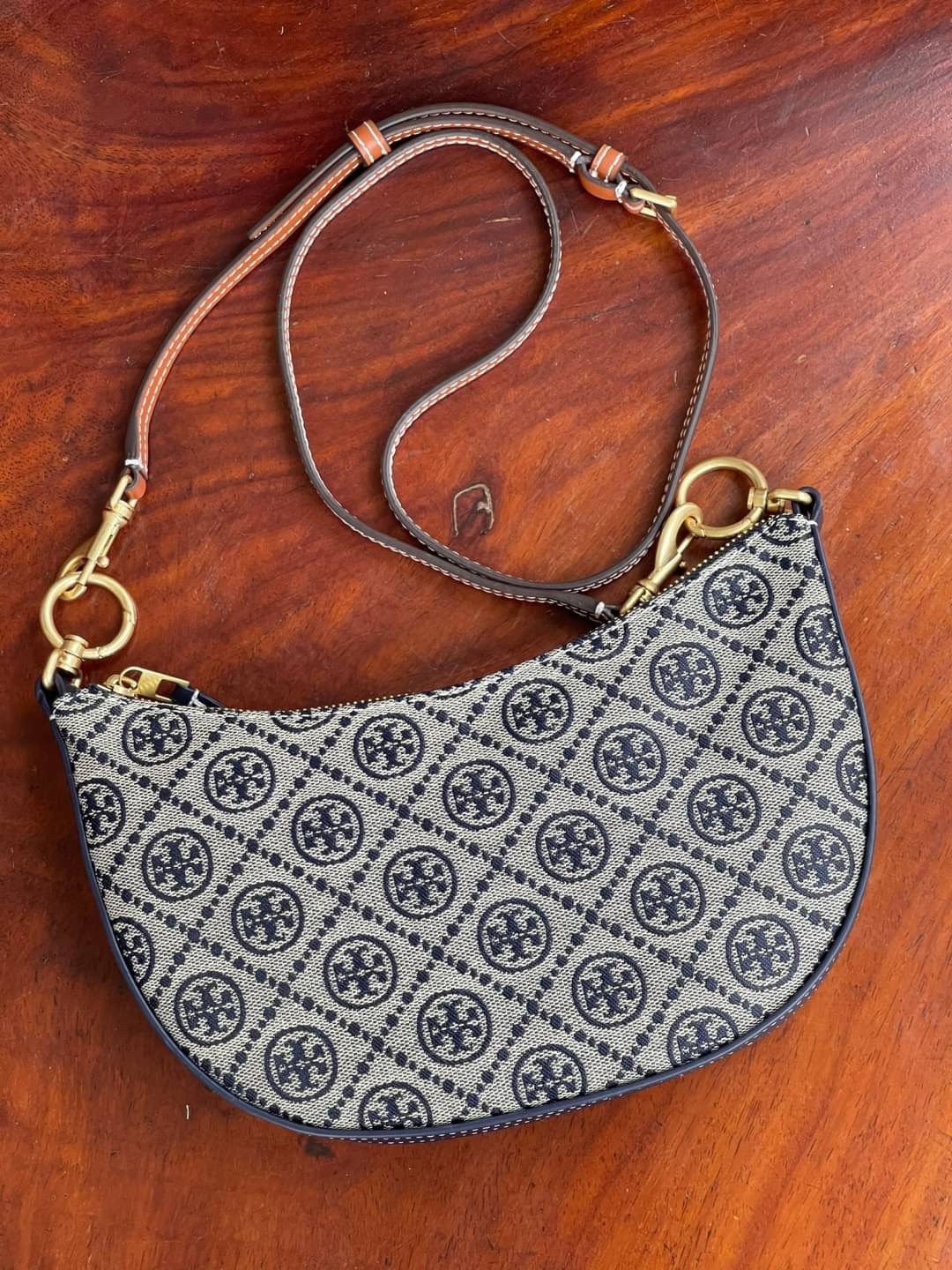 ของแท้ 💯% Tory Burch T monogram jacquard Mini Hobo Bag กระเป๋าลวดลาย T Monogram ใบนี้มาในรูปแบบกระเป๋าทรง Hobo Bag มีความแตกต่างจากกระเป๋าทรงอื่นๆ