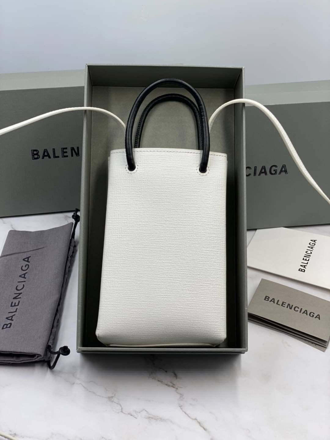 หนังแท้ BALENCIAGA Shopping Phone Pouch leather tote พกกระเป๋าช้อปปิ้งขนาดมินิ ไปทุกที่ในฤดูกาลนี้ ดีไซน์ที่ใช้ได้ทุกวันตั้งแต่หนังแบบมีเท็กซ์เจอร์ ภาพสินค้าถ่ายจากงานขายจริง ใช้งานต่างประเทศได้