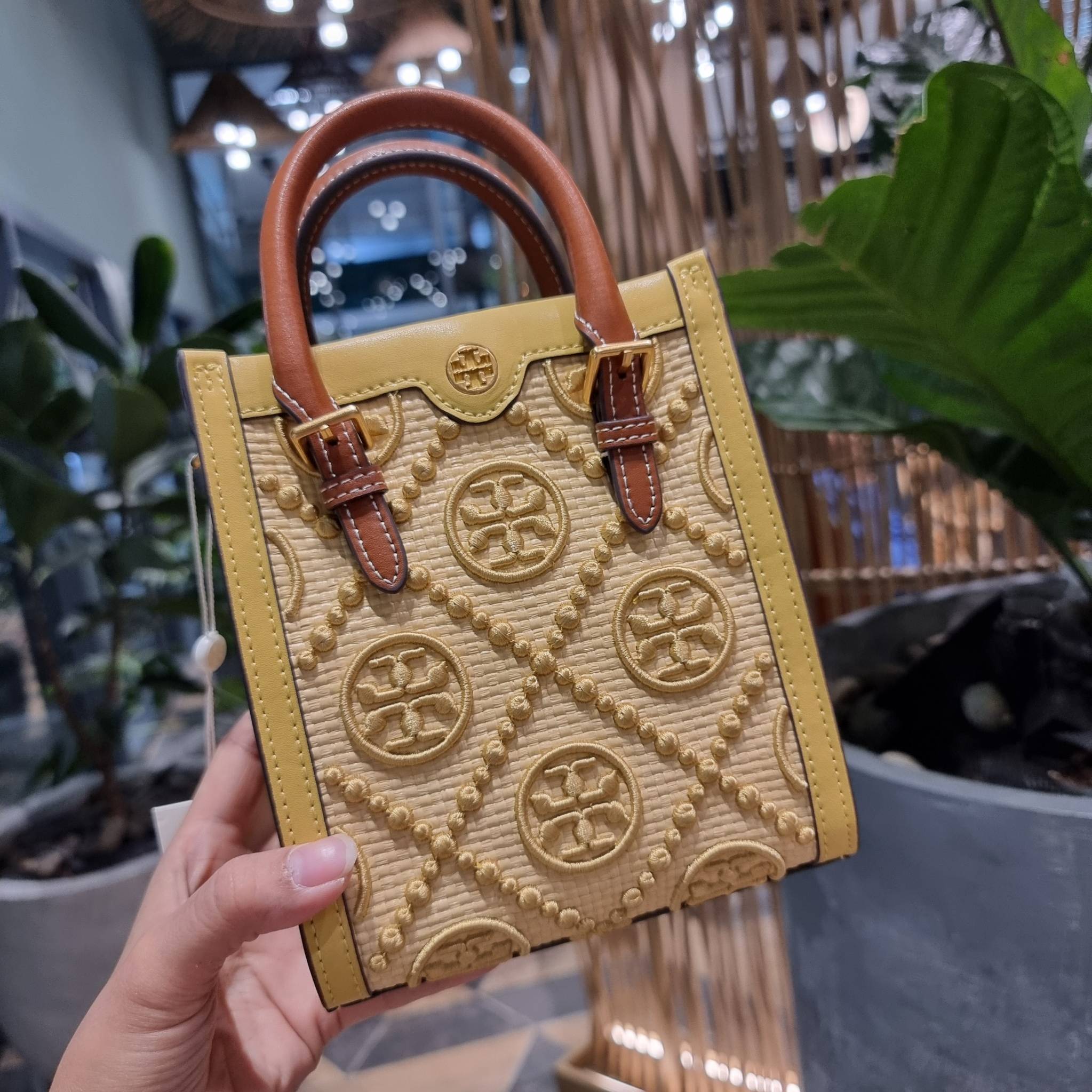 TORY BURCH T MONOGRAM STRAW MINI TOTE สวยสุด ดูแพงสุด!! ต้องยกให้เลย กับไอเท็มนี้ กระเป๋าสะพายทรงโท้ท ไซส์มินิ มีลูกเล่นที่ดีเทลเยอะมาก ด้วยงานฝีมือปักสานด้วยวัสดุจากกธรรมชาติ ถักทอเป็นลายเส้นขึ้นลายนูน ตัดขอบด้วยหนังแท้ และยังโดดเด่นด้วยหูจับในตัวโทนสีอุ