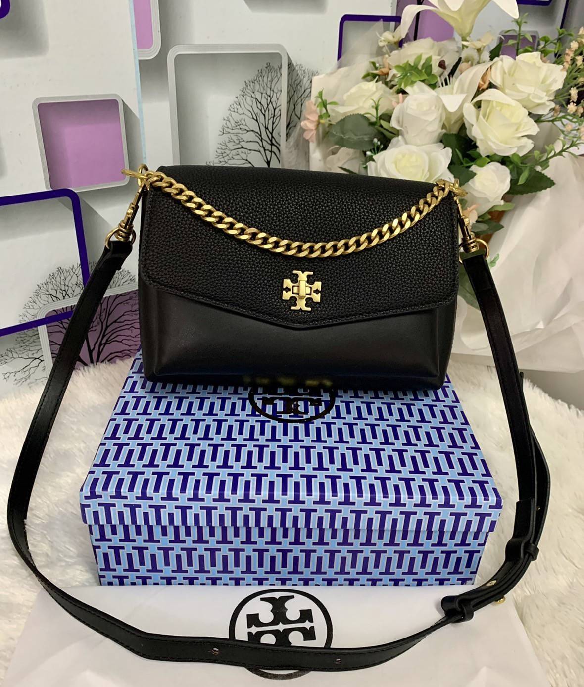 TORY BURCH KIRA MIXED-MATERIALS TOP-HANDLE SATCHEL กระเป๋าสะพายข้าง วัสดุหนังแกะสังเคราะห์ อะไหล่ทอง ด้านหน้าประดับโลโก้แบรนด์ ตกแต่งสายโซ่ห้อยสีทอง (สามารถถอดออกได้) เปิด-ปิดด้วยตัวล็อคหมุน ภายในโล่งกว้าง ซับในบุผ้าลายแบรนด์ แบ่งออกเป็น 3 ช่องใหญ่ พร้อมช