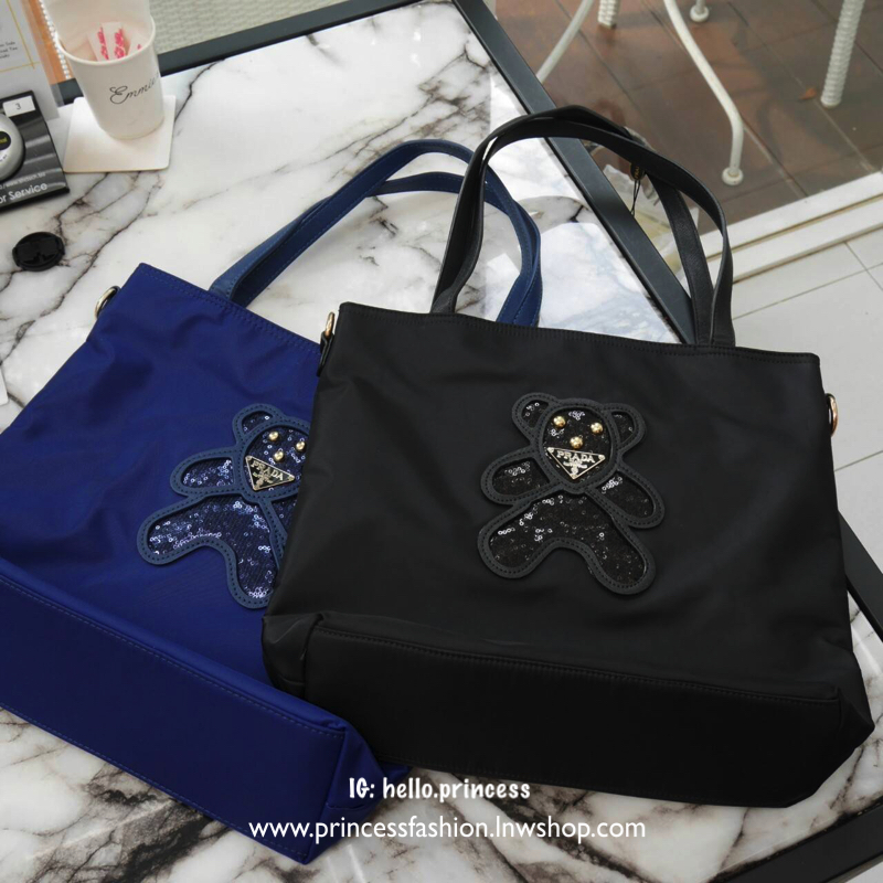 กระเป๋าสะพาย *มีสายยาวให้คะ ทรง TOTE จากแบรนด์ PRADA มาค่า ตัวกระเป๋าเป็น nylon ทั้งใบ สะพายเป็น shoulder bag หรือถือได้ค่ะ ด้านหน้าเป็นลายหมี ปักกลิ้ตเตอร์ + logo brand ใช้แล้วสวยมากๆ อะไหล่ทองหรูมาก จุของคุ้ม ใส่หนังสือ หรือ MacBook ได้ค้า สวยคุ้มที่สุด