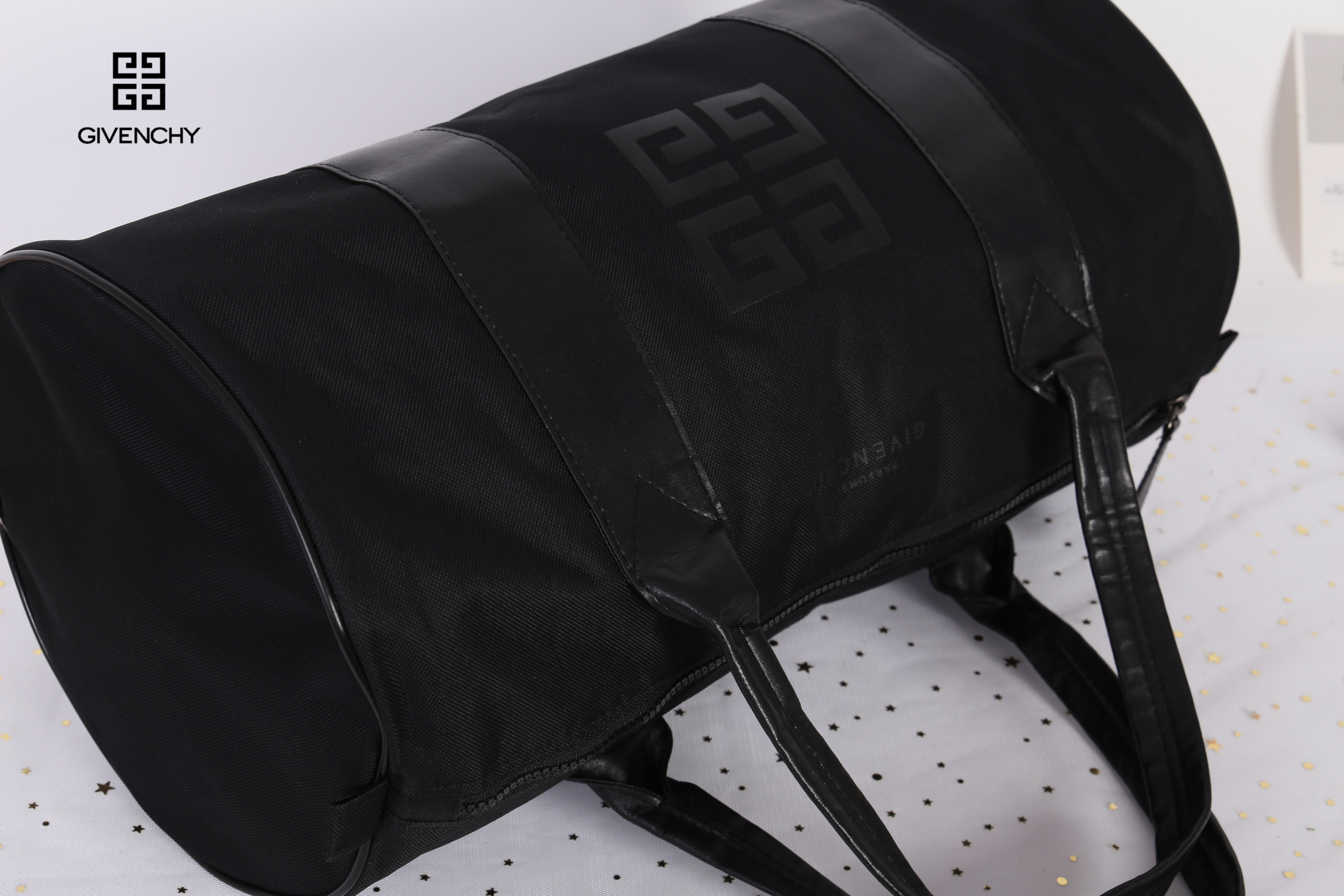 Givenchy Black Oxford Fabric Travel Bag สินค้าเป็นของใหม่ จากเค้าเตอร์เครื่องสำอาง/น้ำหอมของแบรนด์ กระเป๋าใบใหญ่สีดำ ทำจากผ้า Oxford สามารถกันน้ำได้ระดับนึง ด้านในบุด้วยผ้าซับสีดำอีกชั้น รุ่นนี้เป็นทรงกระบอก ตัวสายสะพายไหล่ทำจากหนัง แข็งแรงและทนทาน ใช้เป็