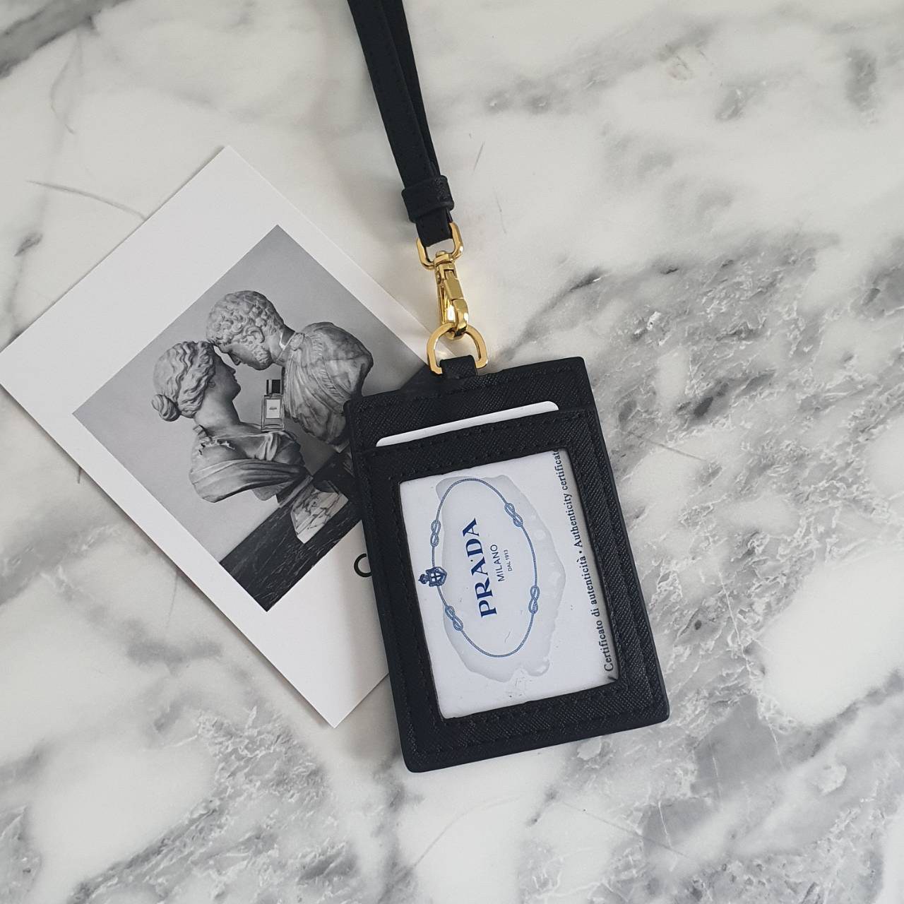 สิ้นสุดการรอคอย!! พร้อมส่งที่ไทยแล้วค่ะ สายคล้องบัตรสุดคลาสสิค จากงานพรีเมี่ยมกิ้ฟท์แบรนด์ดังอย่าง PRADA วัสดุหนังพรีเมี่ยม SAFFIANO อะไหล่ทอง ปั้มแบรนด์ ด้านหน้ามีช่องใส่บัตร1ใบ ประกับโลโก้PRADA และด้านหลังใส่บัตรได้อีกหนึ่งใบ(แบบใส) สำหรับโชว์บัตร ไอเท็