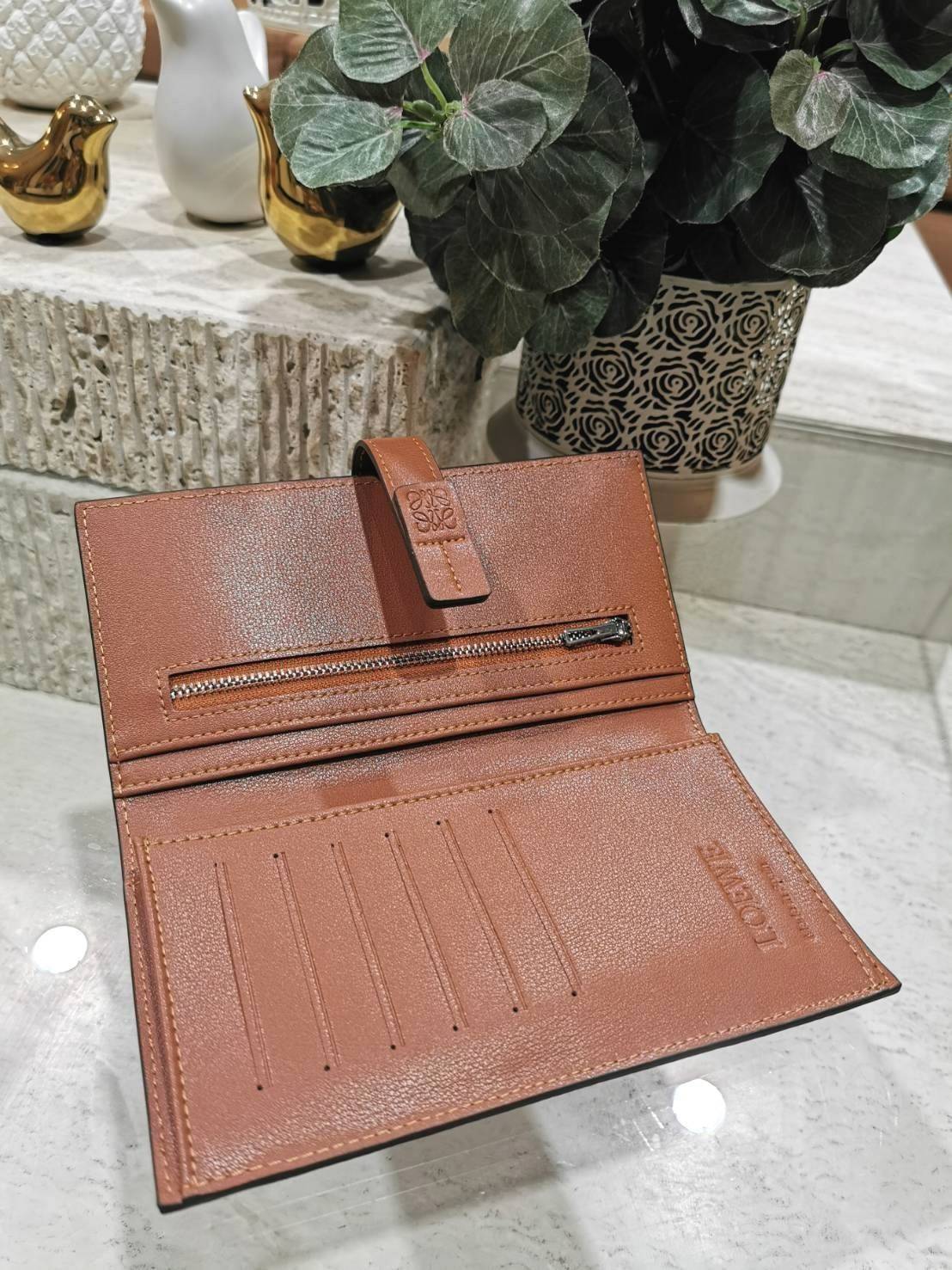 LOEWE LONG WALLET BAG วัสดุหนังแท้เทคเจอร์สวยอยู่ทรงปั้มโลโก้แบรนด์ด้านหน้าเปิดปิดด้วยกระดุม ภายในมีช่องใส่ธนบัตรหลายช่อง ช่องหลักสามารถใส่มือถือได้ มีช่องซิปใส่เหรียญ ช่องใส่ธนบัตรใส่แบงก์พันได้ สวยน่าใช้ พร้อมส่งที่ไทยสุดคุ้มห้ามพลาด!